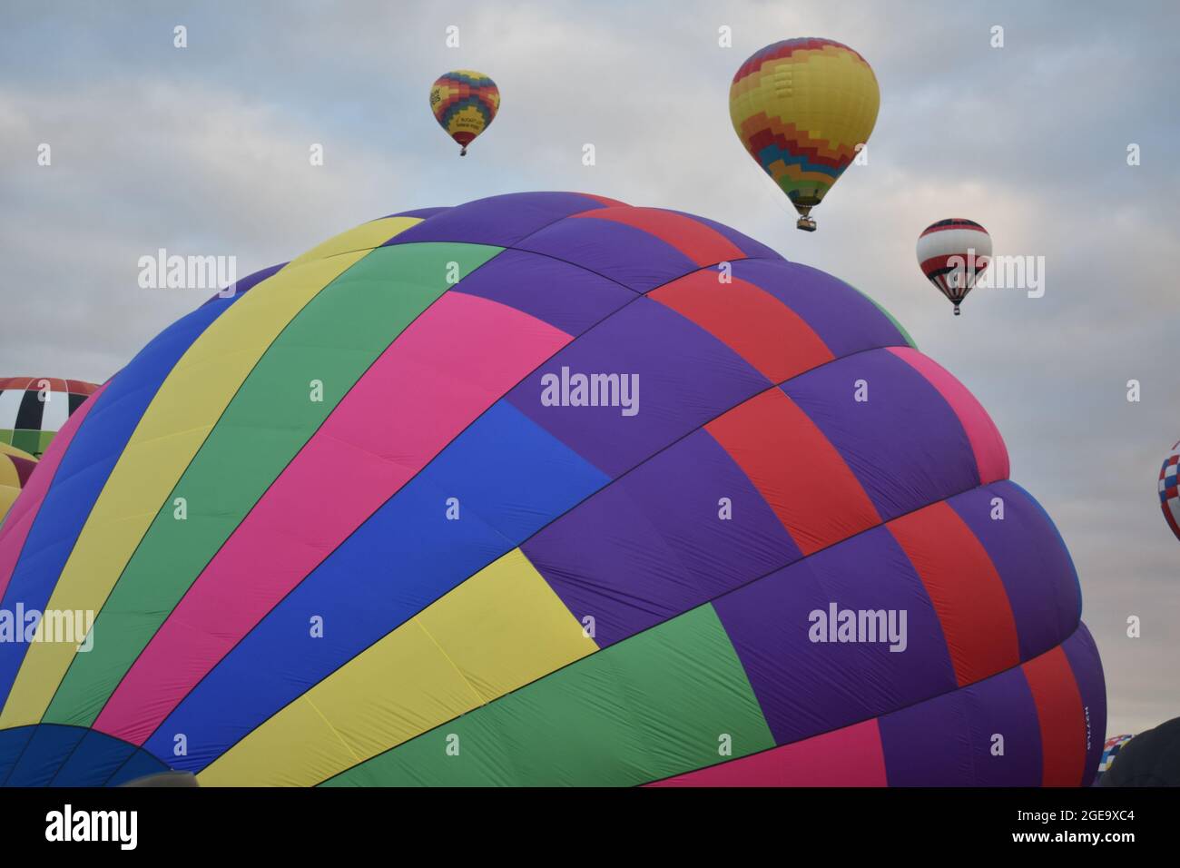 Hot air balloons inflating on the cloudy sky background Stock Photo - Alamy