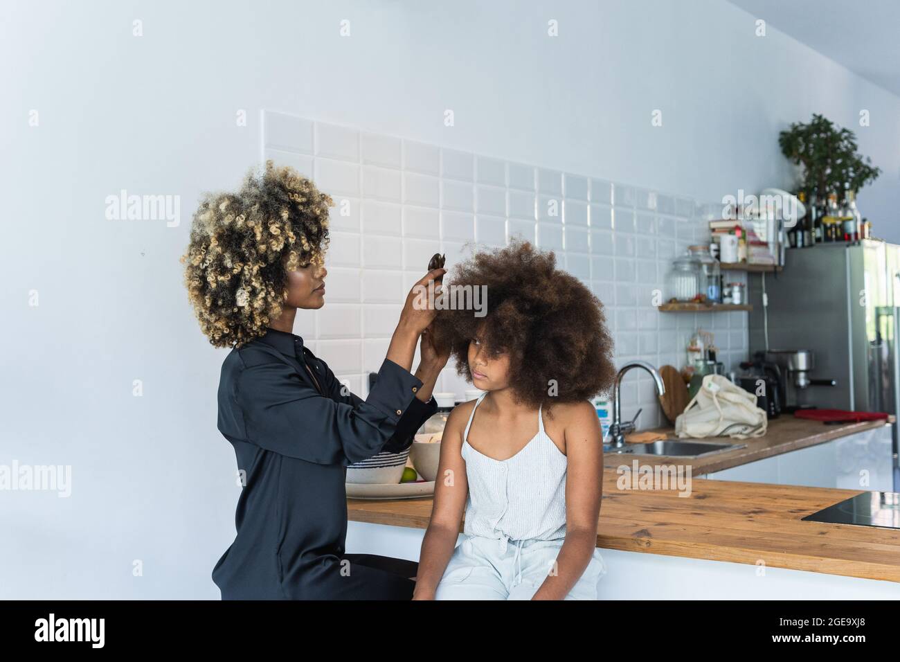 African American female using comb to do Afro hairstyle to cheerful black girl in kitchen at home Stock Photo - Alamy African American female using comb to do Afro hairstyle to cheerful black girl in kitchen at home Stock Photo - Alamy
