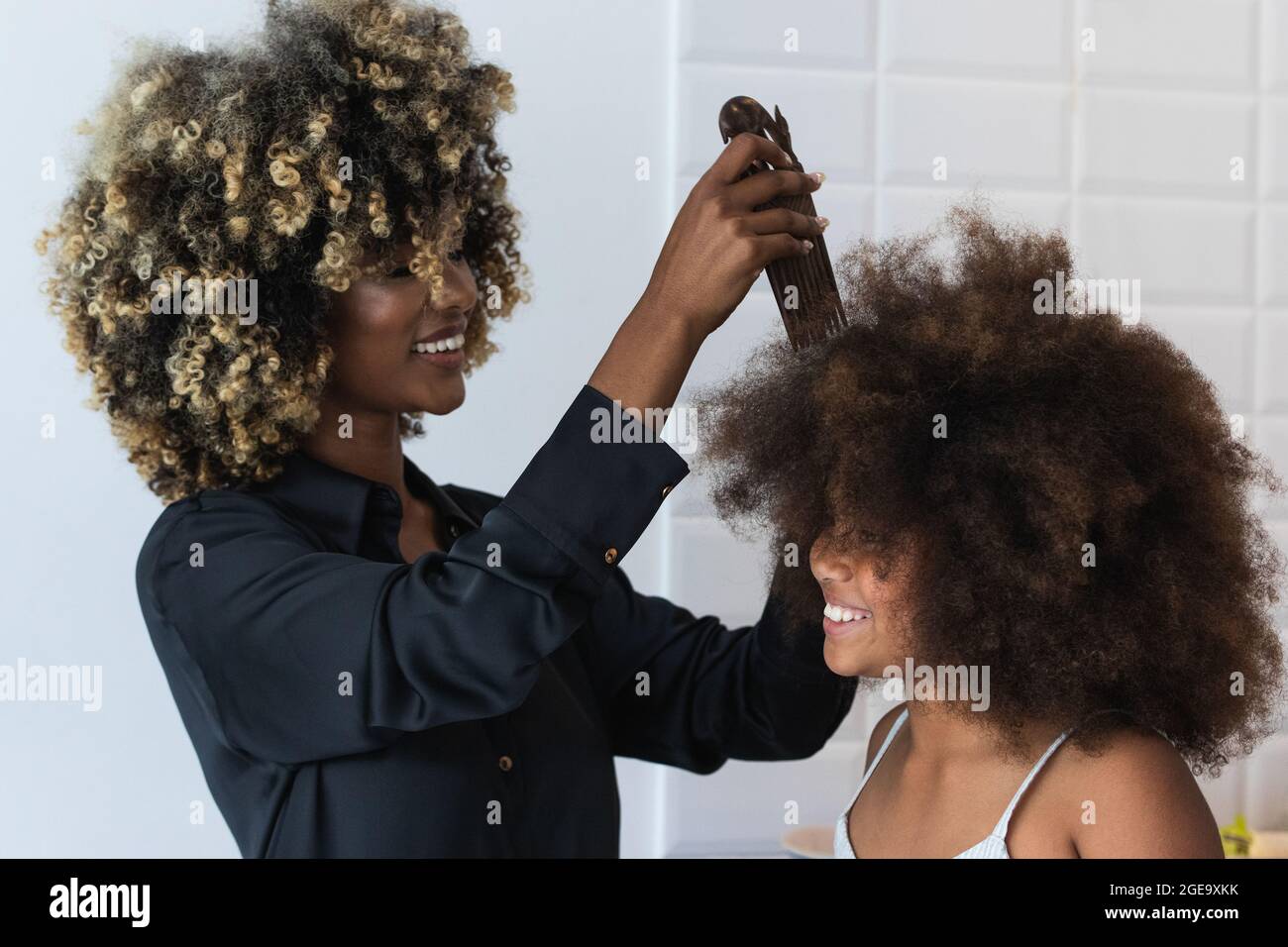 African American female using comb to do Afro hairstyle to cheerful black girl in kitchen at home Stock Photo - Alamy African American female using comb to do Afro hairstyle to cheerful black girl in kitchen at home Stock Photo - Alamy