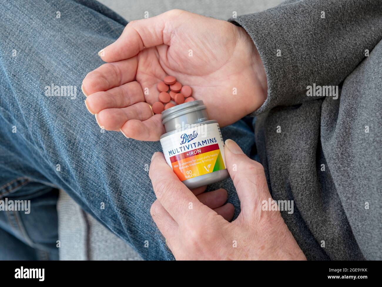 Close up of man holding plastic bottle of multi vitamins and iron tablets. Stock Photo