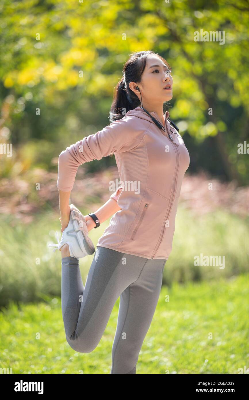 Young Chinese woman exercising in park Stock Photo - Alamy