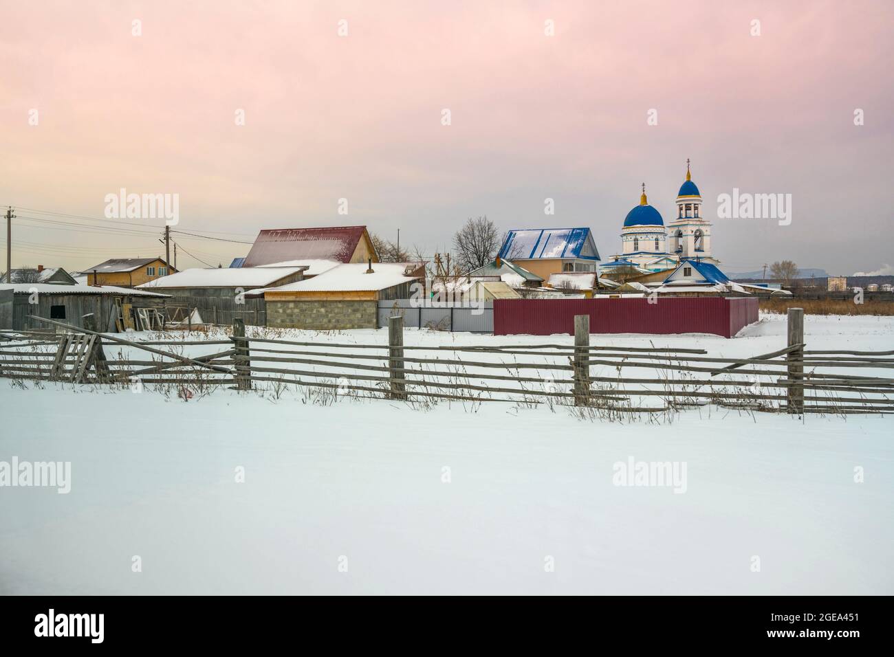The domes of a small Orthodox church rise over a village in the Ural Mountains region in Russia. Stock Photo