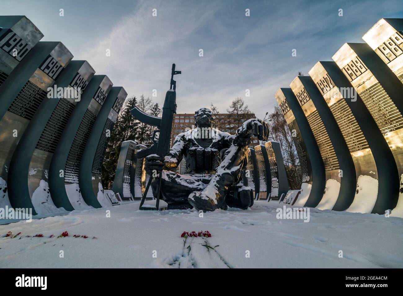 Roses grace the freshly fallen snow in front of the Afghanistan War Memorial known as the Black Tulip in downtown Ekaterinburg in Russia. Stock Photo