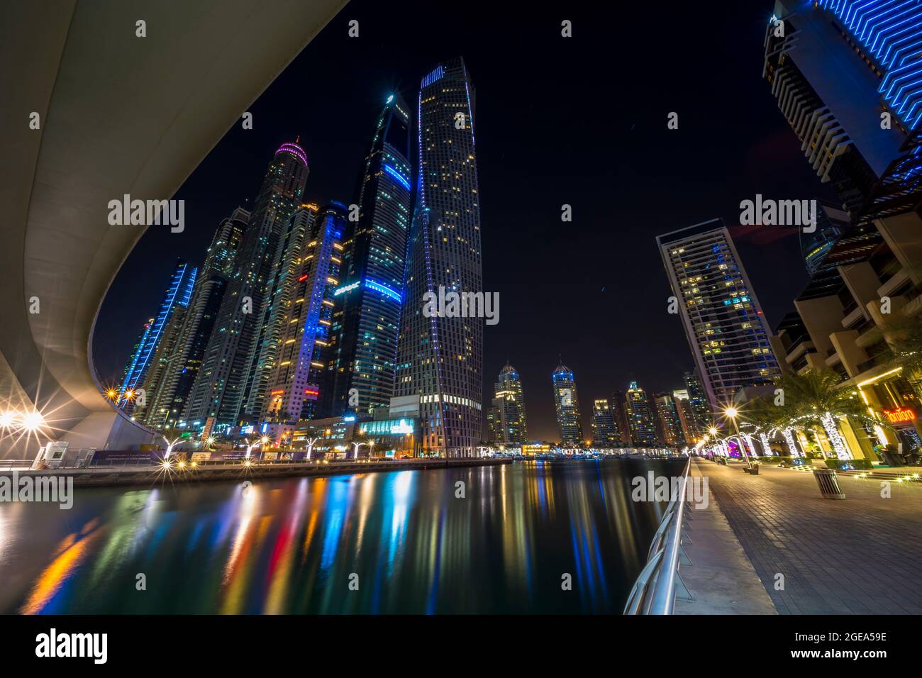 Colourful pillars of radiant light stream across the still waters of the Dubai Marina beneath some of the world's tallest residential buildings. Stock Photo