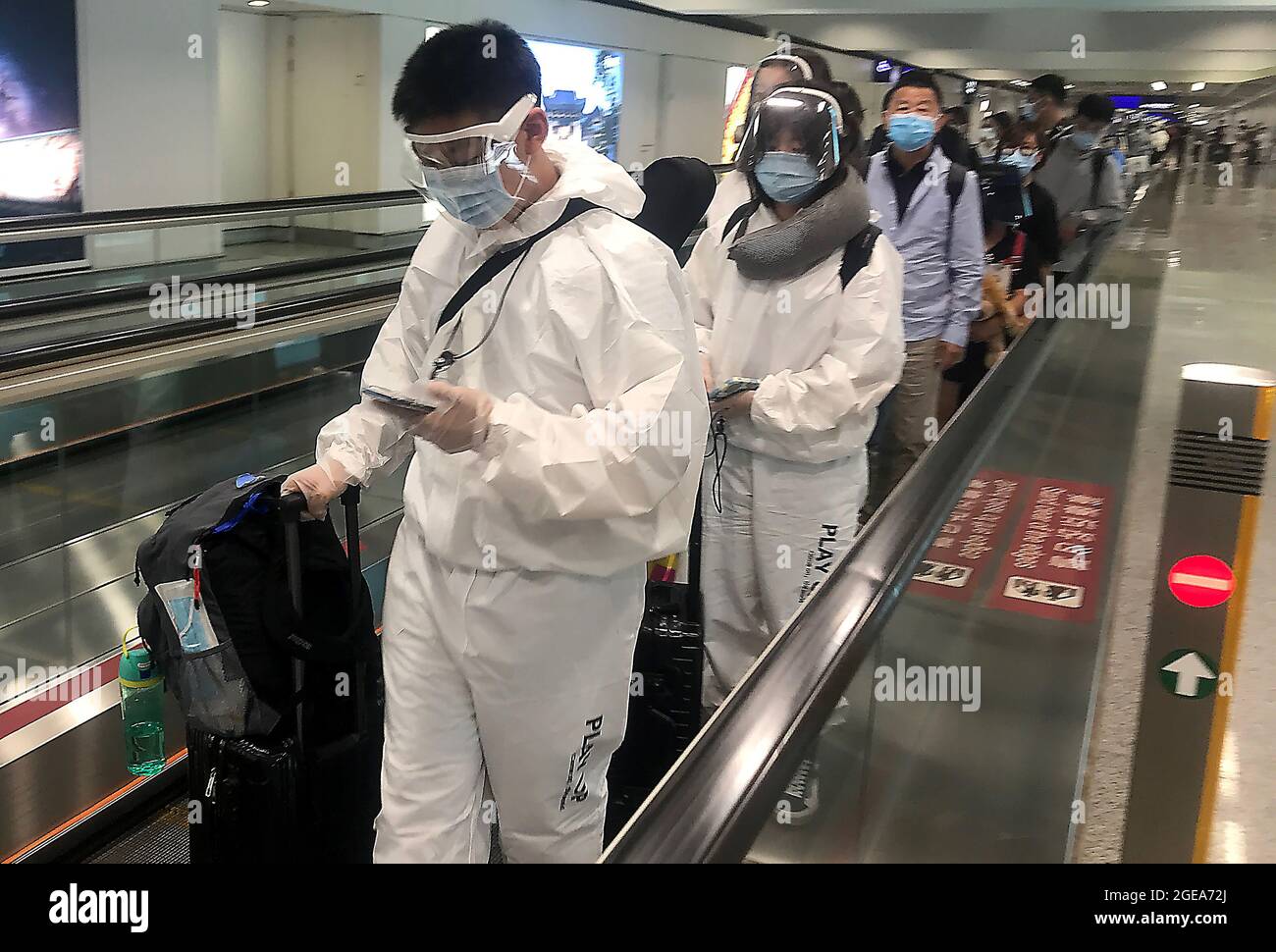Hong Kong, China. 18th Aug, 2021. Passengers wear full body personal protective equipment (PPE) while transiting through Hong Kong's international airport on Wednesday, August 18, 2021. Hong Kong remains on high alert for the threat of a new Covid outbreak as it remains a major travel hub and destination in Asia. Photo by Stephen Shaver/UPI Credit: UPI/Alamy Live News Stock Photo