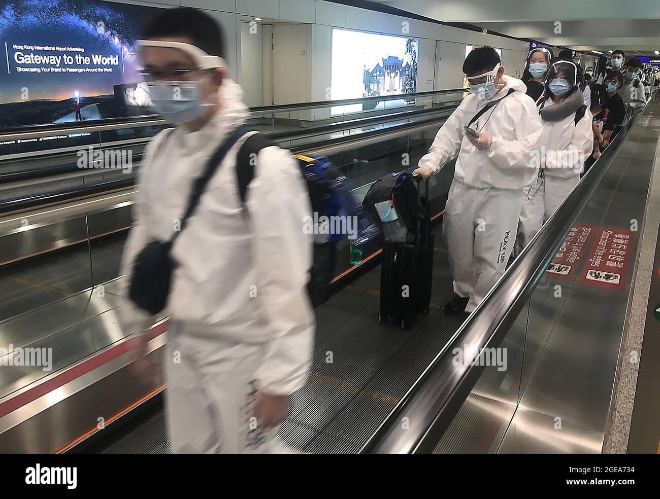 Hong Kong, China. 18th Aug, 2021. Passengers wear full body personal protective equipment (PPE) while transiting through Hong Kong's international airport on Wednesday, August 18, 2021. Hong Kong remains on high alert for the threat of a new Covid outbreak as it remains a major travel hub and destination in Asia. Photo by Stephen Shaver/UPI Credit: UPI/Alamy Live News Stock Photo