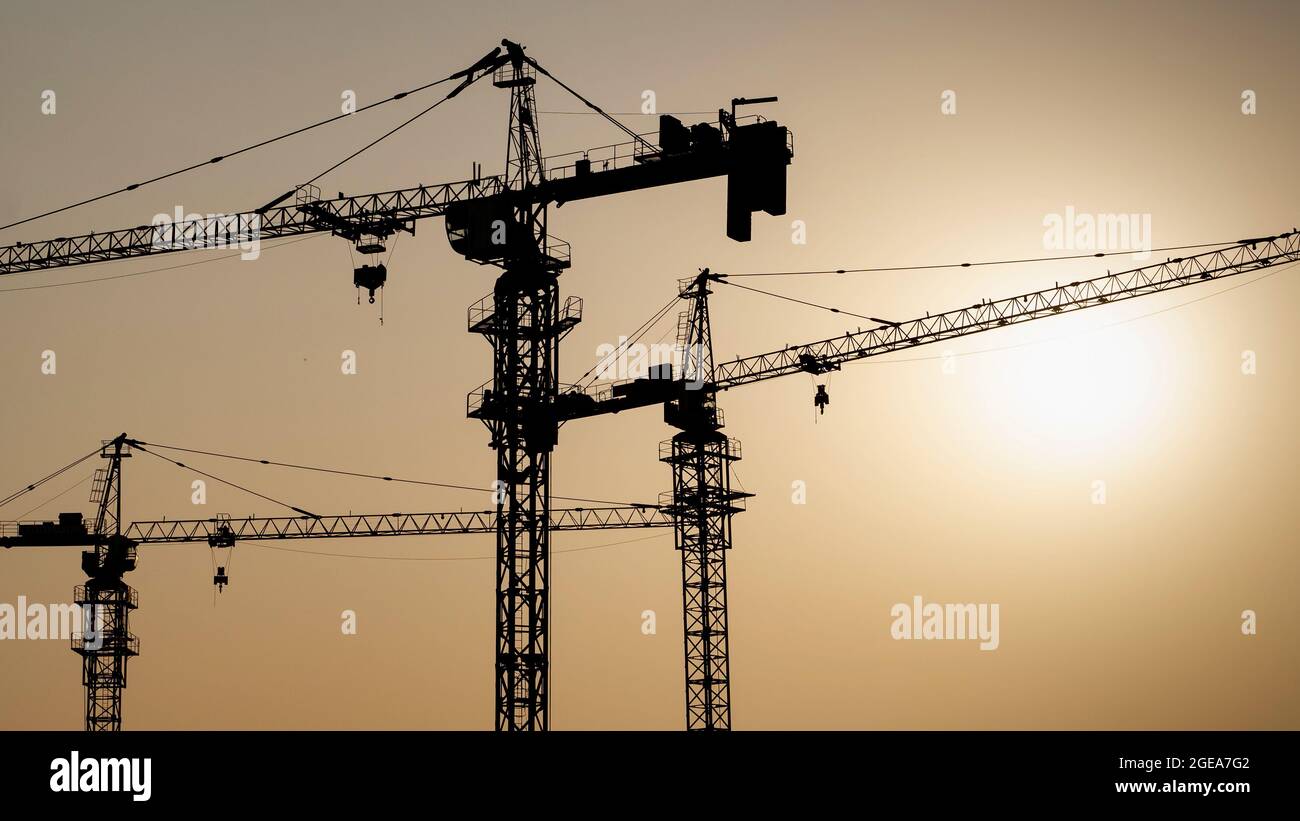 Tower crane at building construction site silhouette during sunrise ...