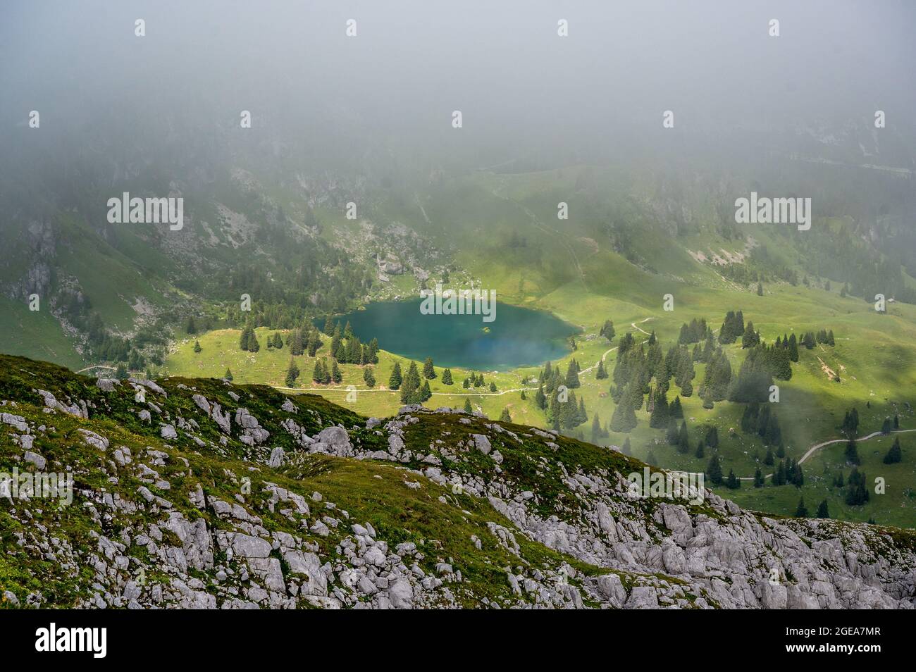 misty view into Diemtigtal with Seebergsee Stock Photo