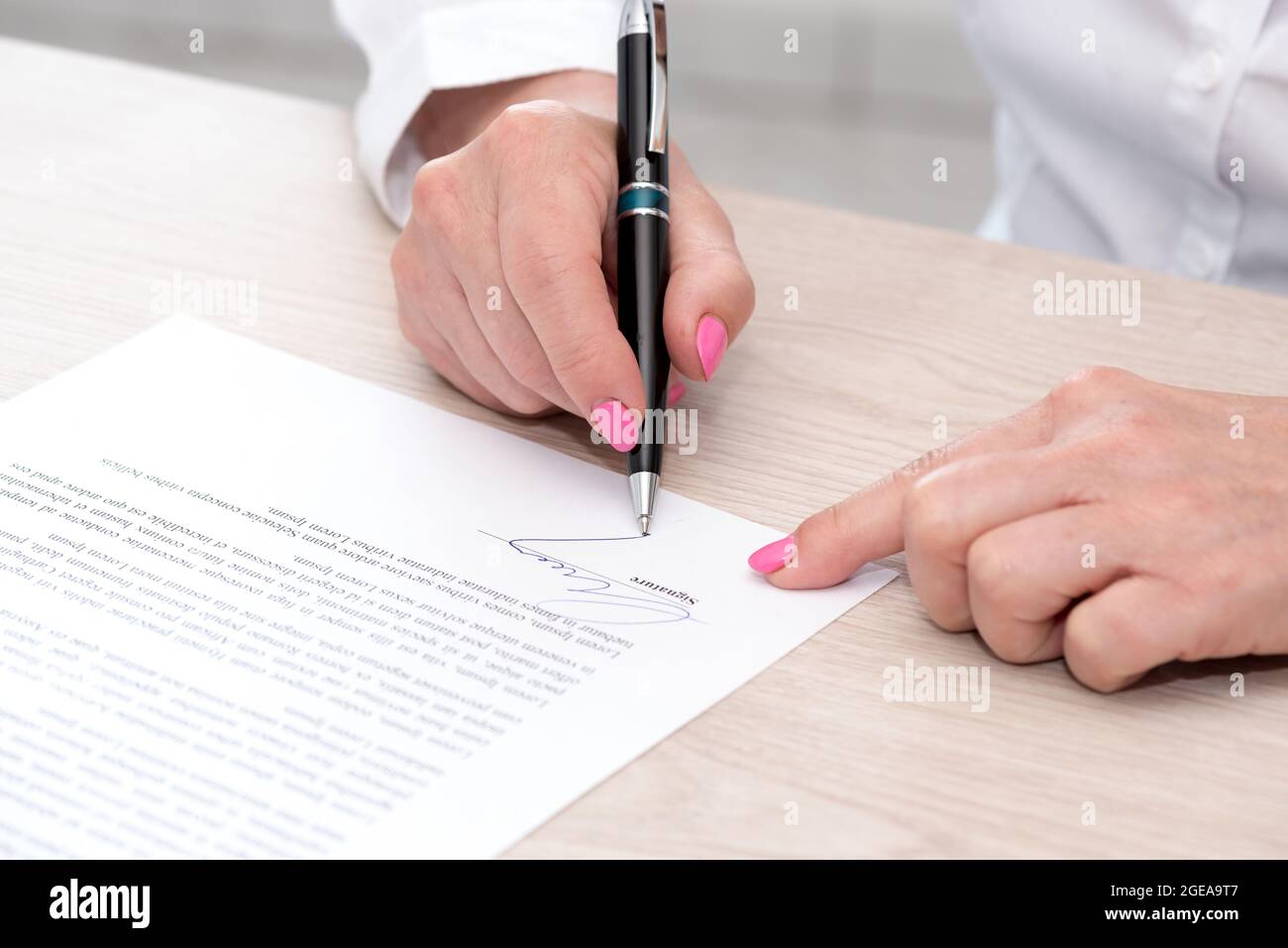 Woman signing a legal document Stock Photo - Alamy