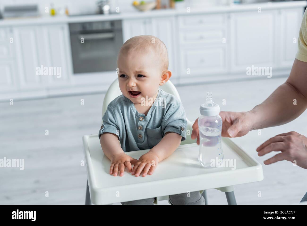 https://c8.alamy.com/comp/2GEACN7/baby-daughter-crying-near-father-and-bottle-on-high-chair-2GEACN7.jpg