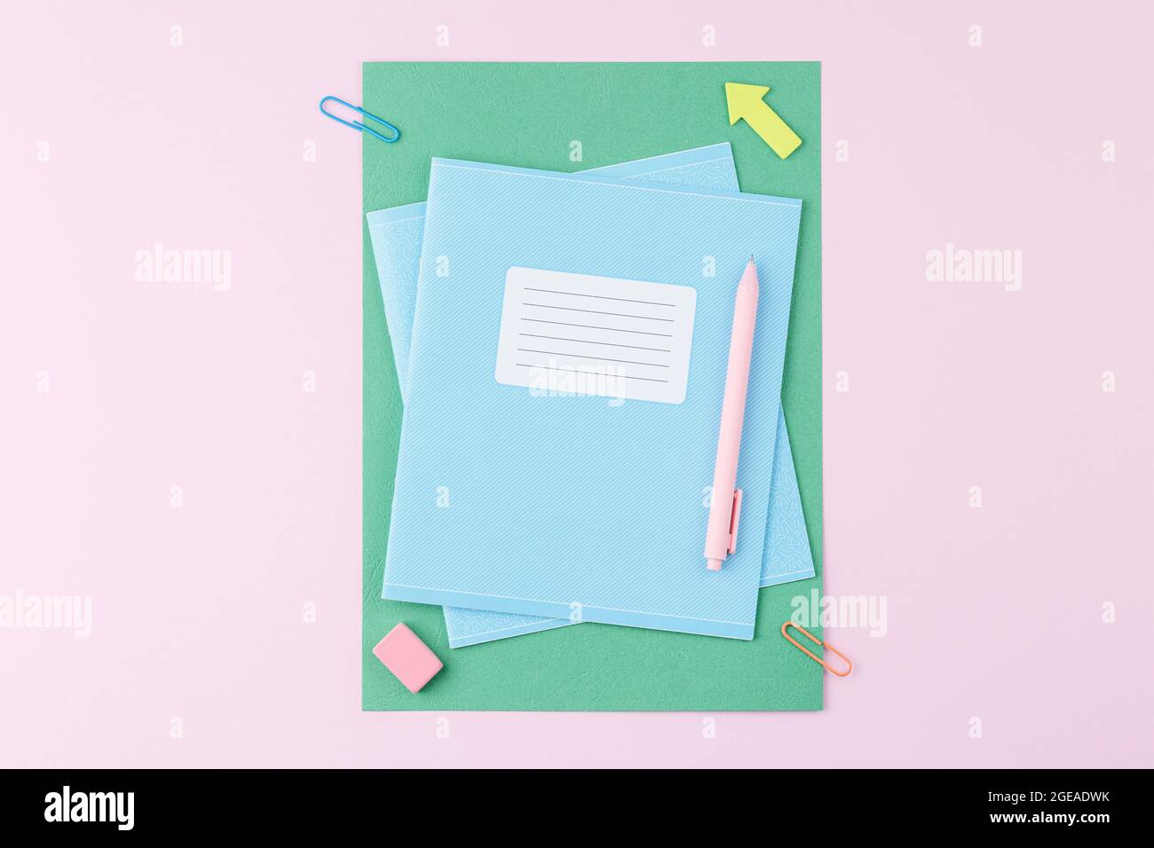 Notebook with school supplies on pink background Stock Photo