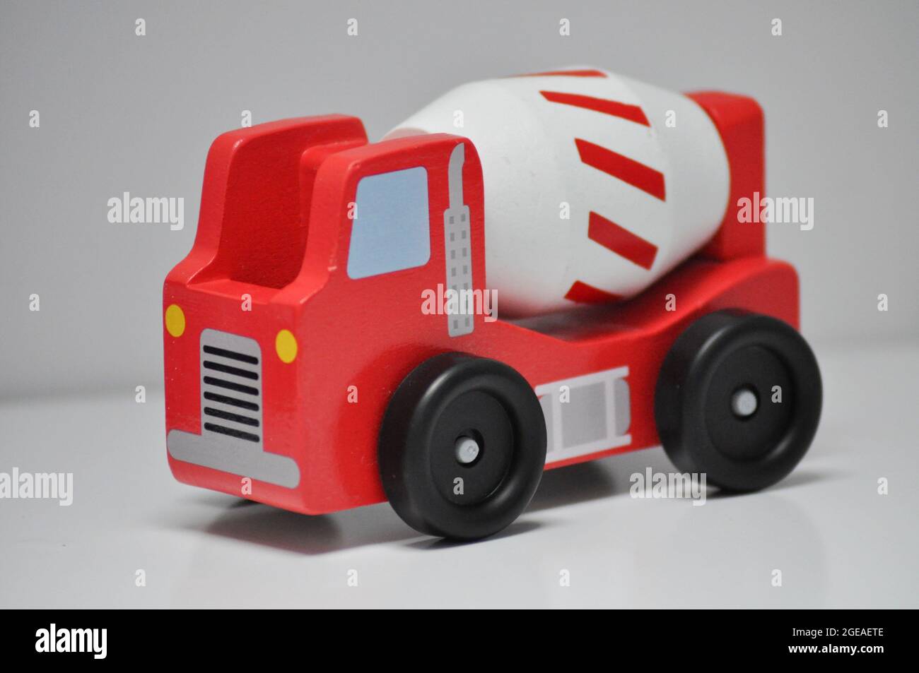 Red lorry with white cement mixer - wooden construction toy set against a white background Stock Photo