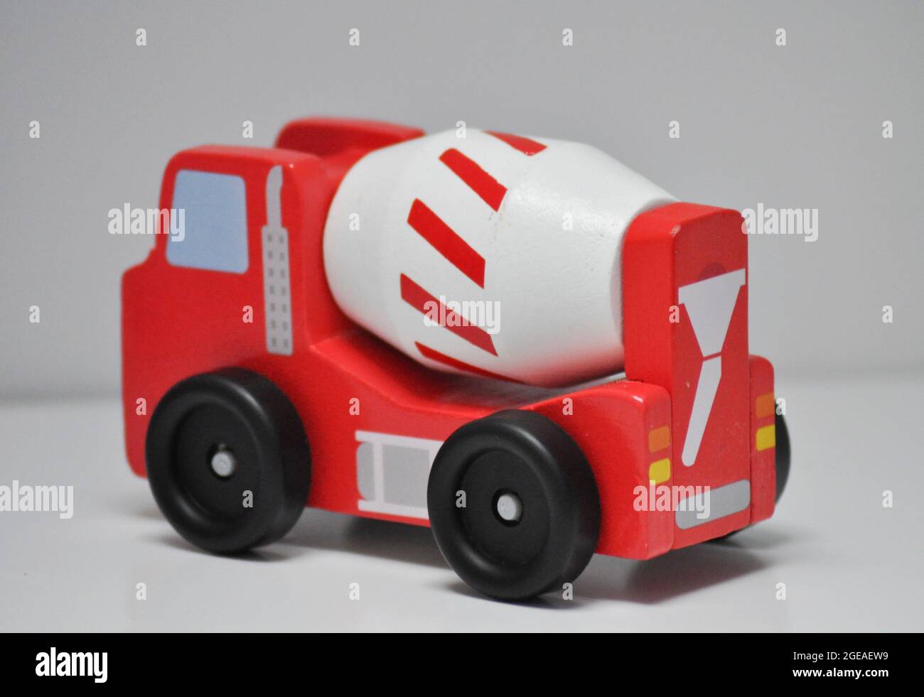 Red lorry with white cement mixer - wooden construction toy set against a white background Stock Photo