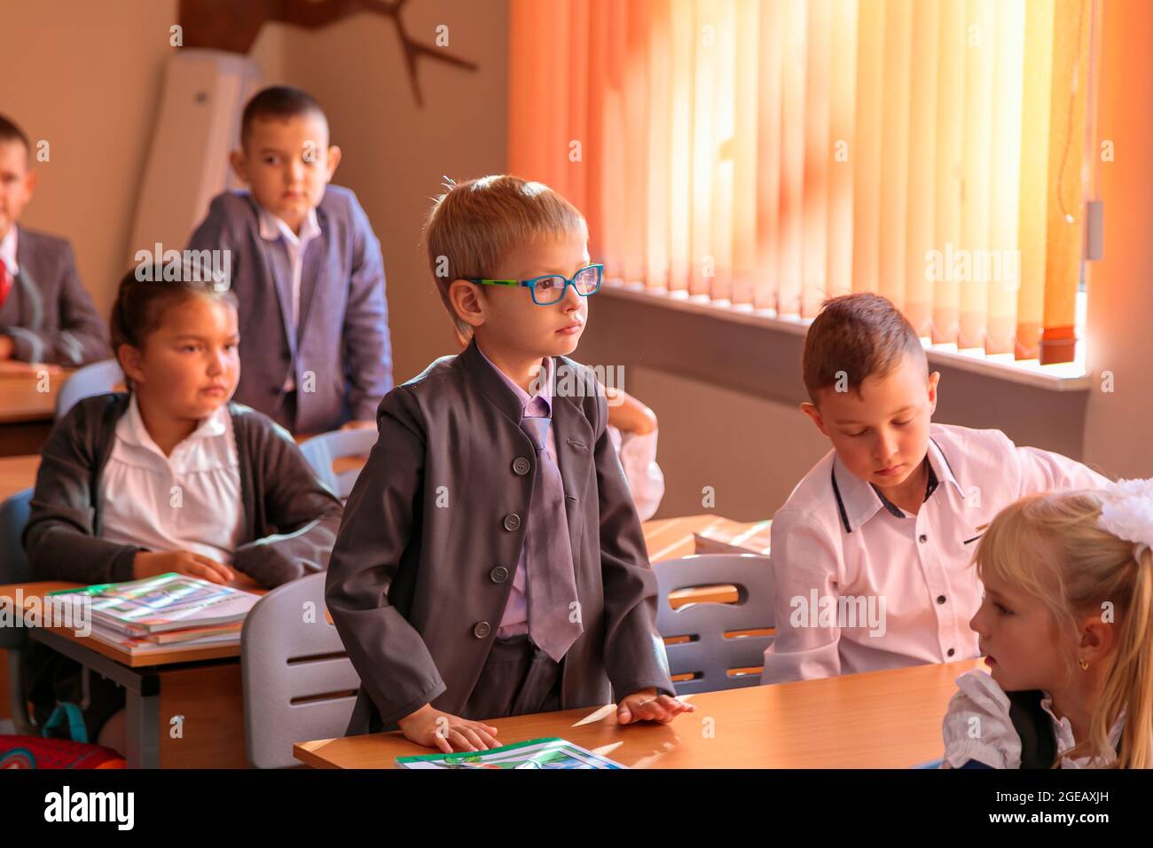 The first grader stands at the desk and answers the teacher's question. Moscow, Russia, September 2, 2019 Stock Photo