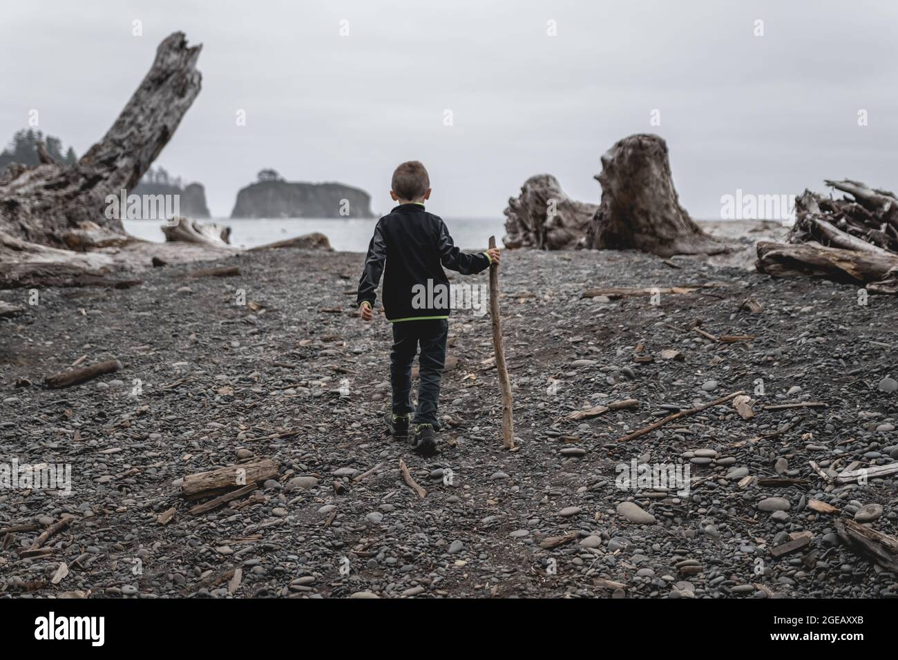 Young boy walking onto Rialto Beach in Olympic National Park. Stock Photo