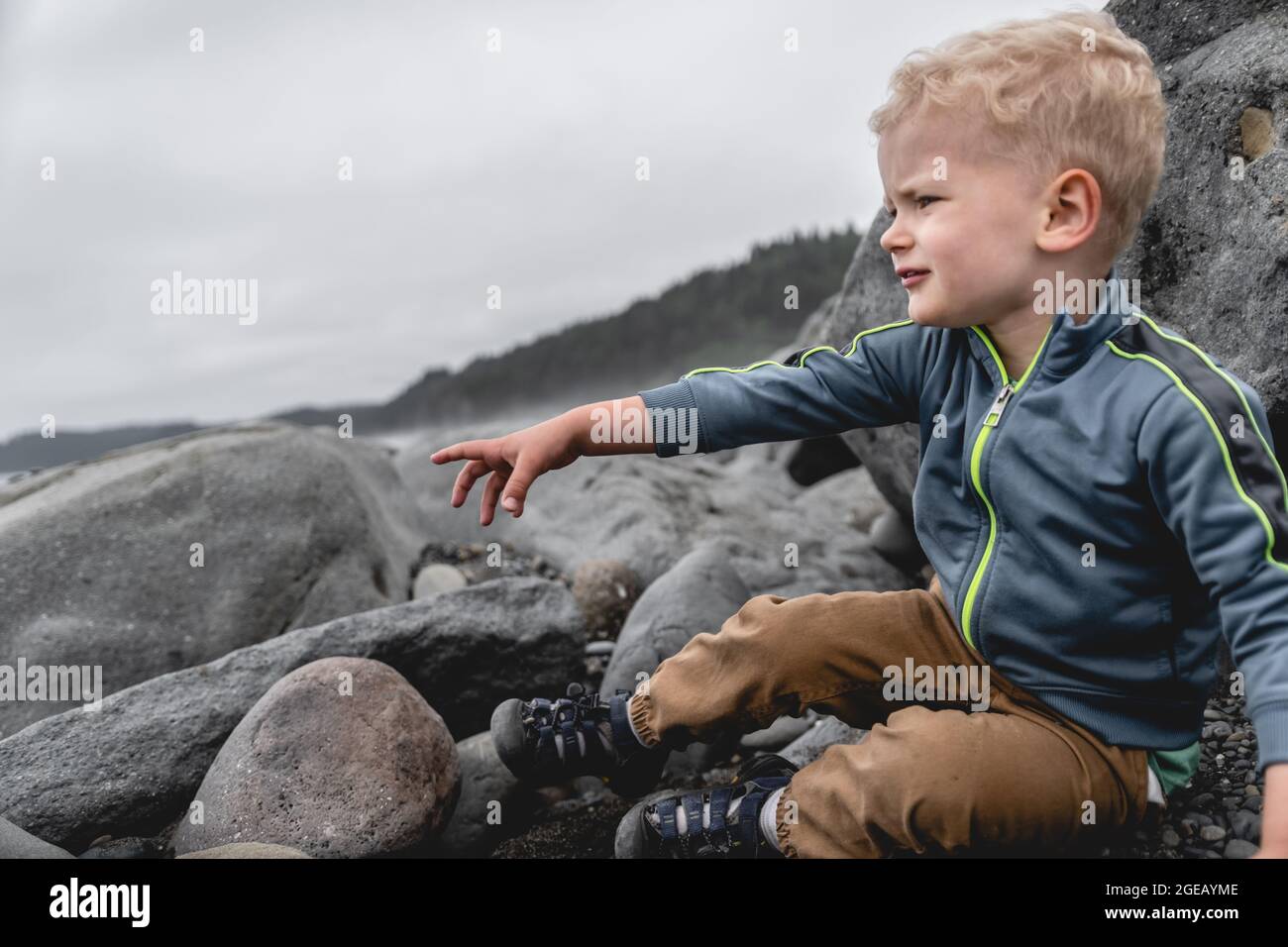 Young boy looking out at the waves on Rialto Beach in Olympic National Park. Stock Photo