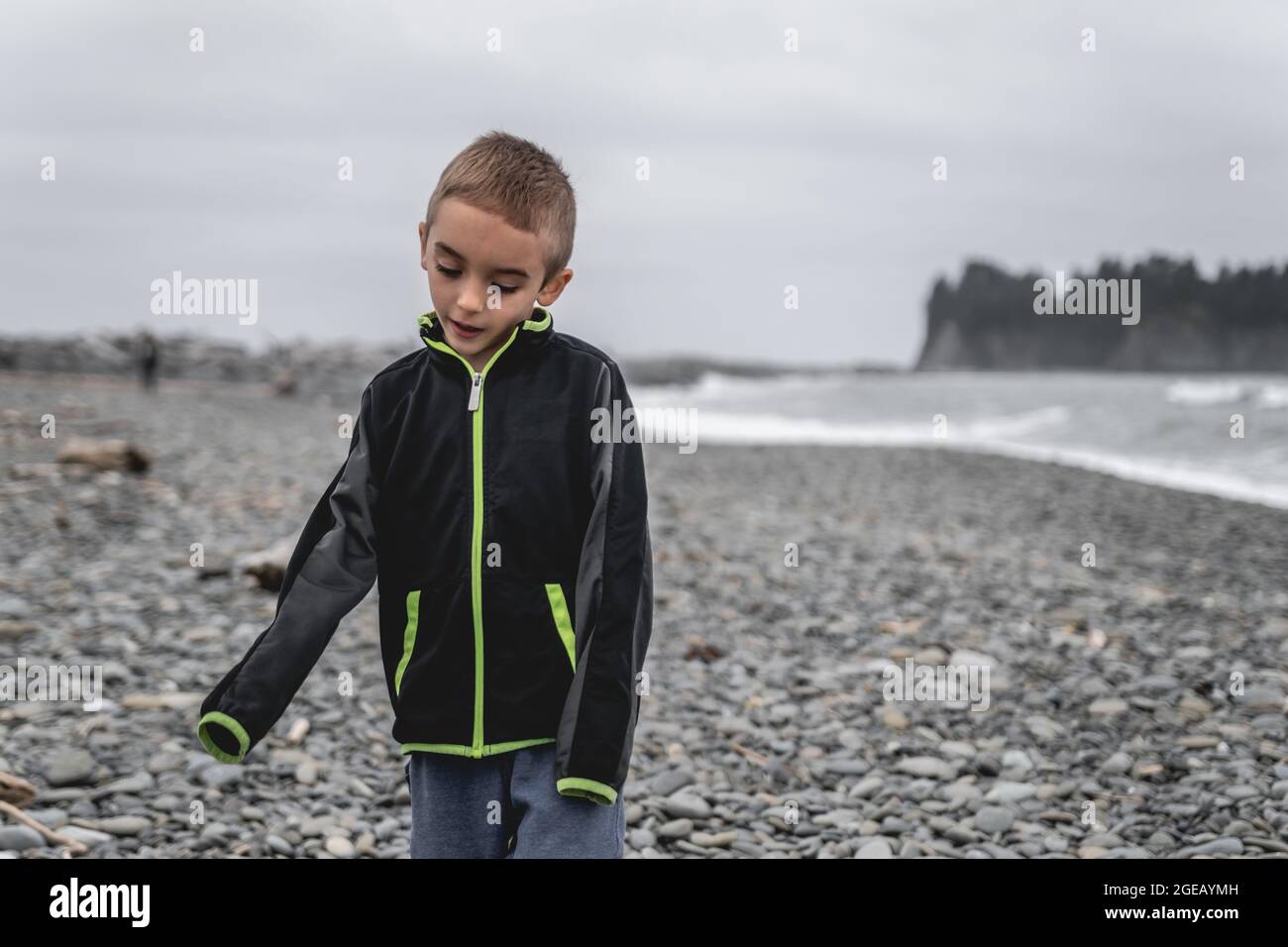 Young boy walking along Rialto Beach in Olympic National Park. Stock Photo