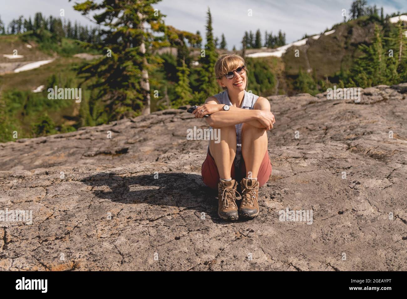 Young woman sitting on a rock at Heather Meadows in the Mt. Baker-Snoqualmie National Forest. Stock Photo