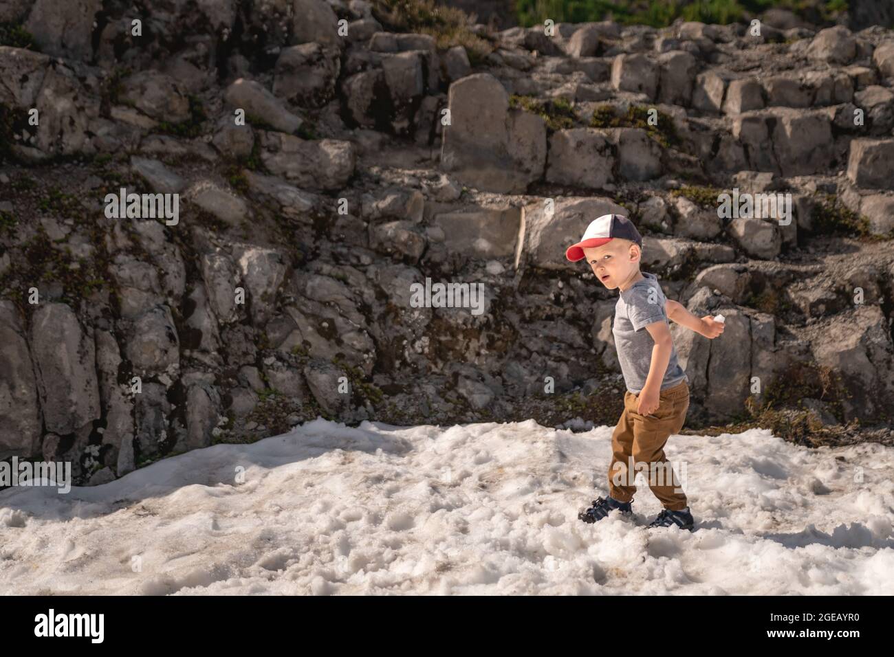 Young boy throwing snowballs in summer at Heather Meadows in the Mt. Baker-Snoqualmie National Forest. Stock Photo