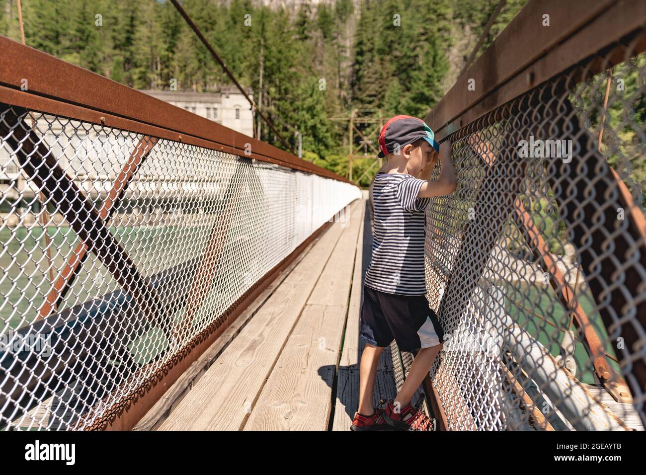 Boy looking at the Skagit River on a suspension bridge in North Cascades National Park. Stock Photo