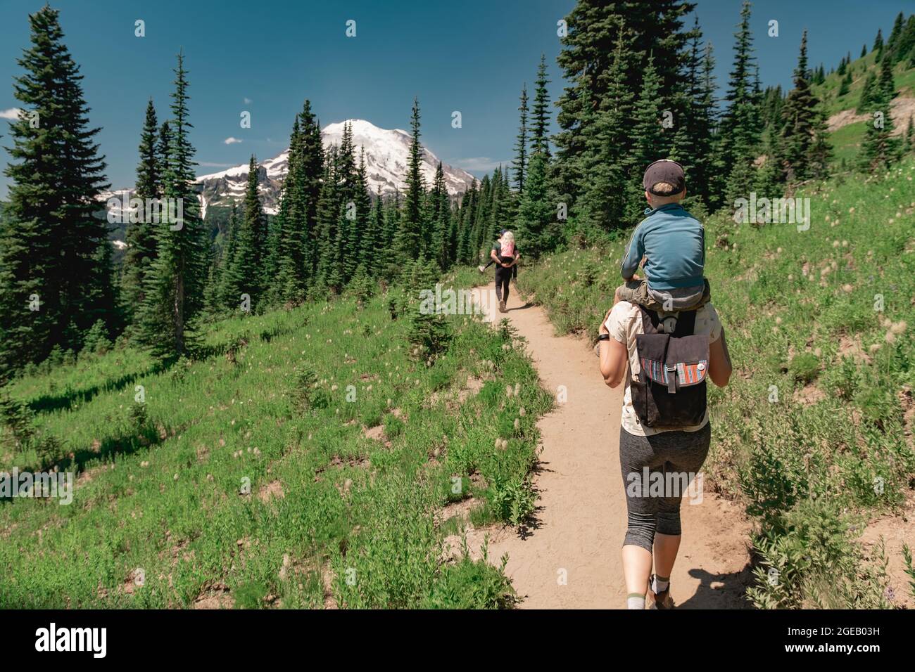 Young family hiking toward Mt Rainier on the Naches Peak Loop Trail in Mt. Rainier National Park Stock Photo