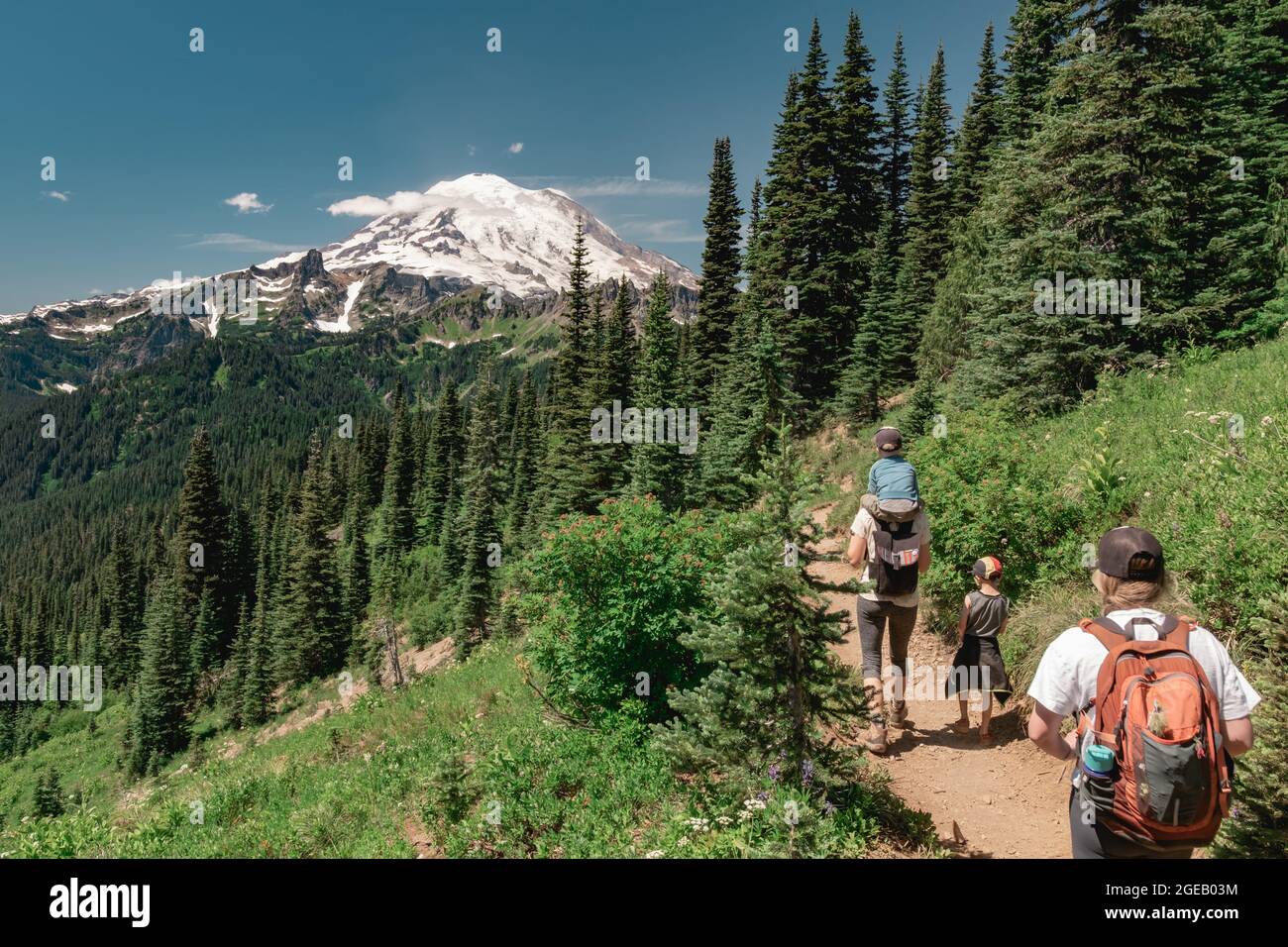 Young women hiking with kids toward Mt Rainier on the Naches Peak Loop Trail in Mt. Rainier National Park Stock Photo