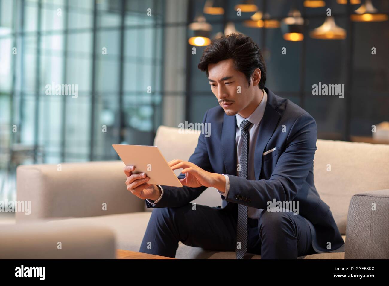 Successful Chinese businessman using digital tablet Stock Photo - Alamy