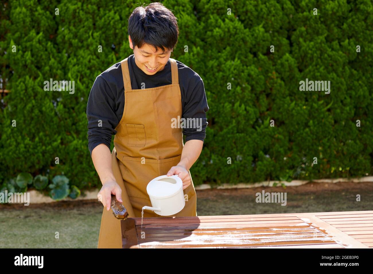 Asian man watering garden on hi-res stock photography and images - Alamy