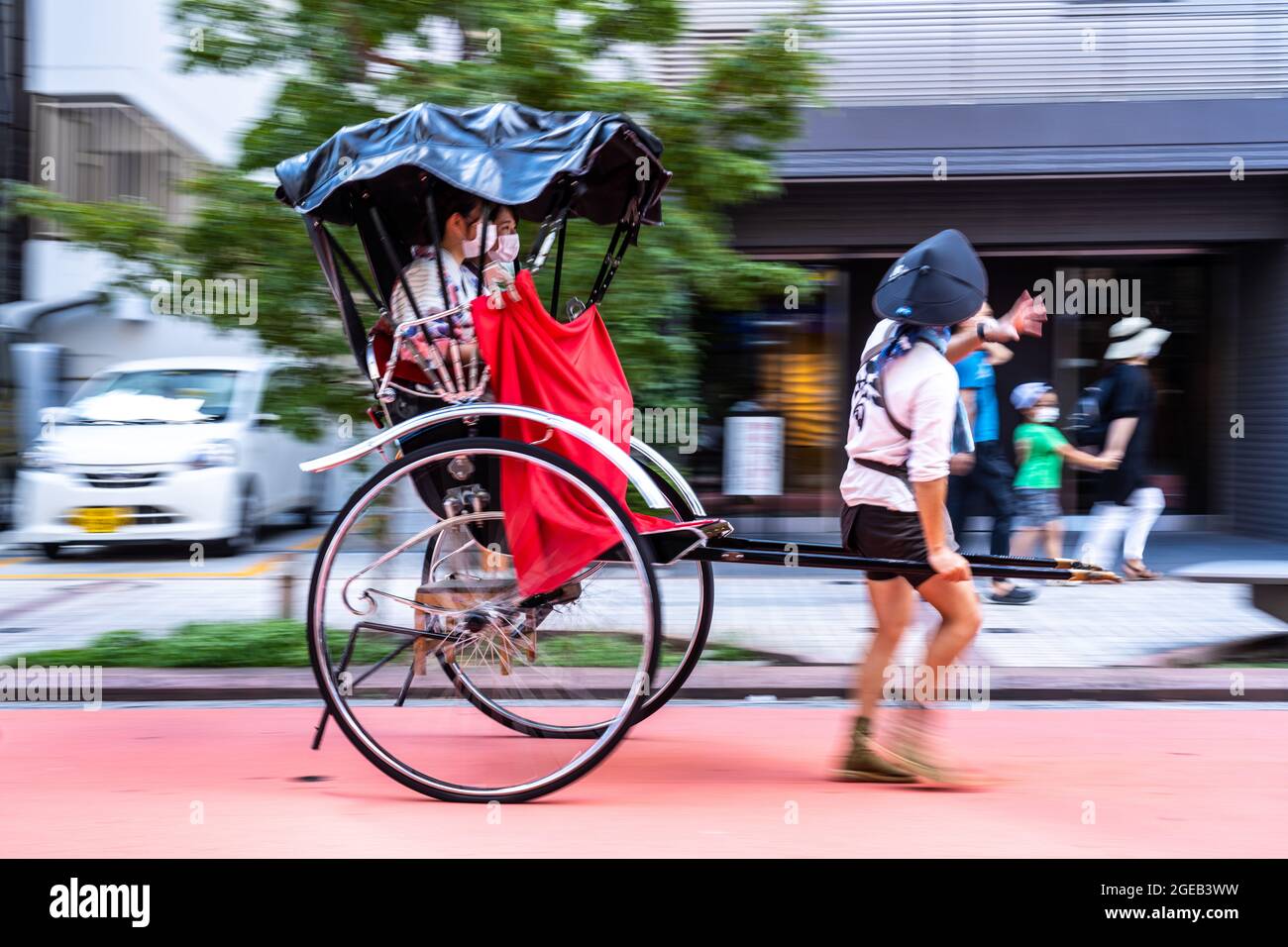 A pulled rickshaw or jinrikisha transports tourists around the Sensoji ...
