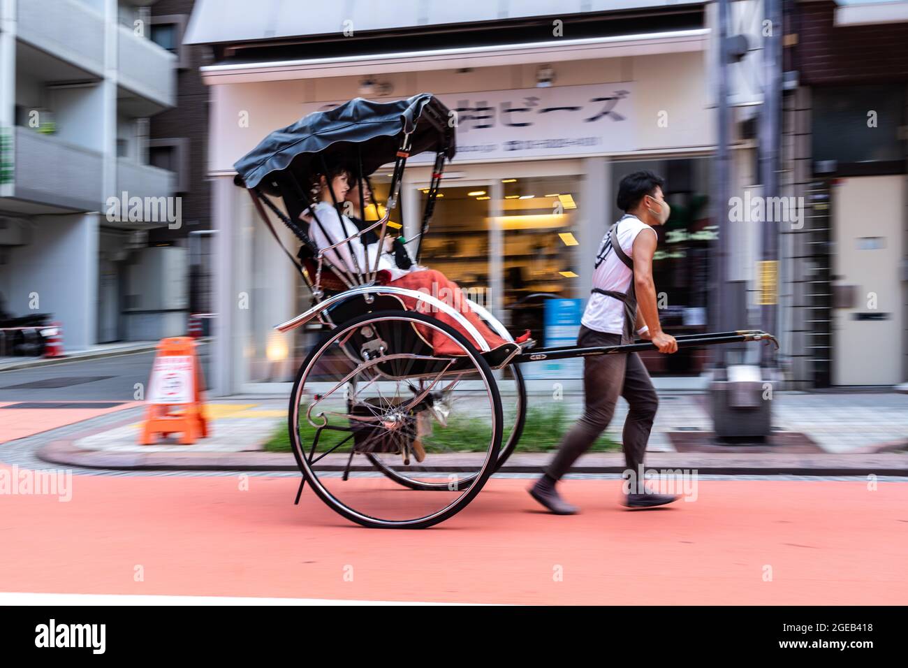 A pulled rickshaw or jinrikisha transports tourists around the Sensoji ...