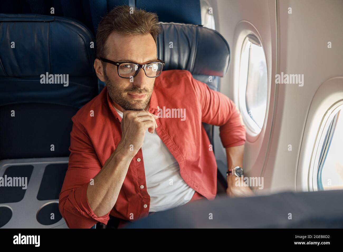 Afrikanische amerikanische Geschäftsmann mit schlafbrille sitzen in der  Nähe von Gadgets in privaten Flugzeug Stockfotografie - Alamy