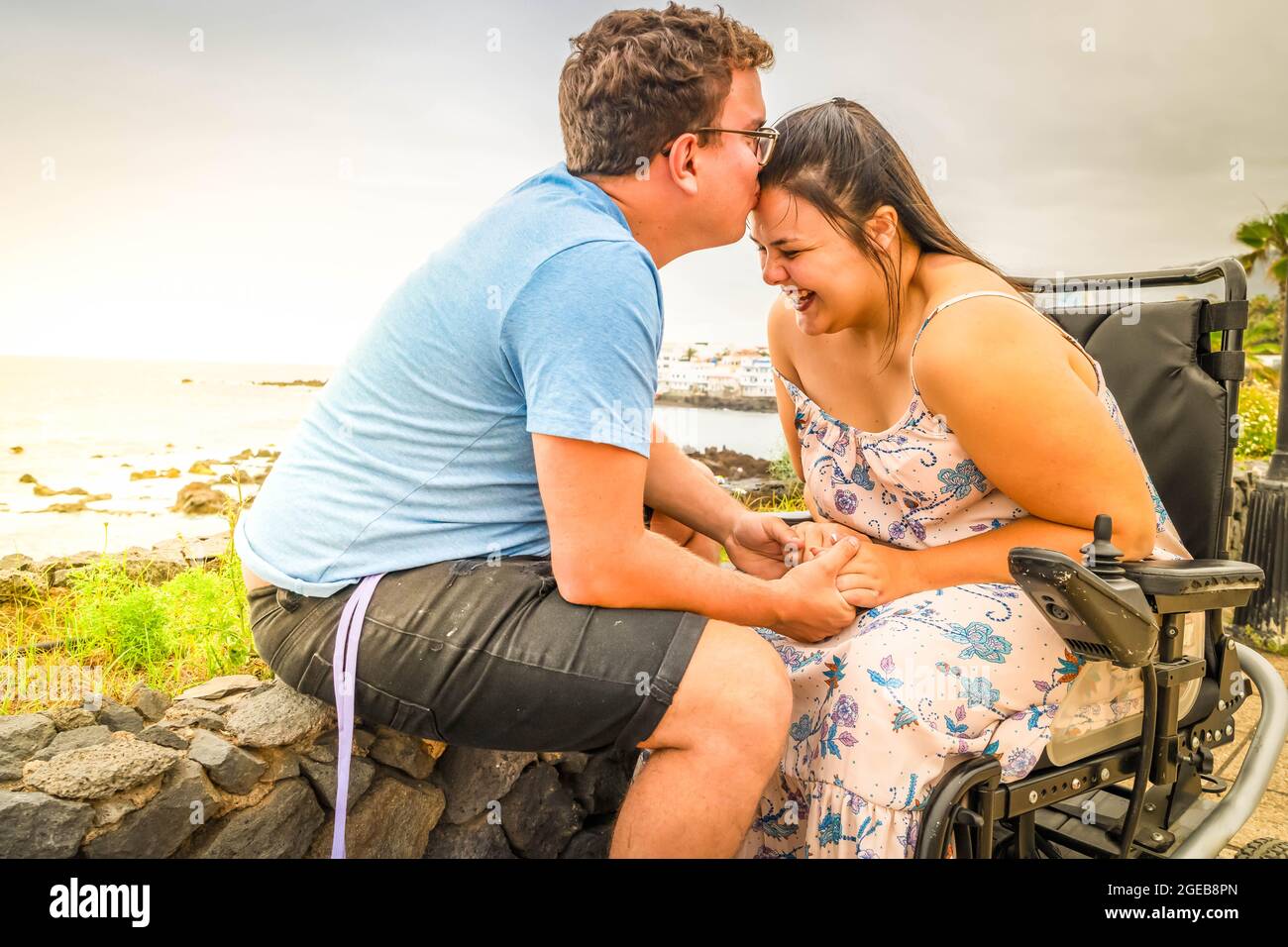 Disabled woman in wheelchair holding hand of her boyfriend while dating ...