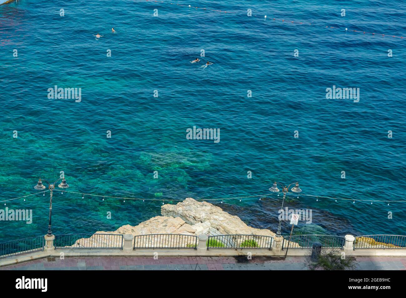 Sliema rocky beach and promenade pavement in Malta Stock Photo