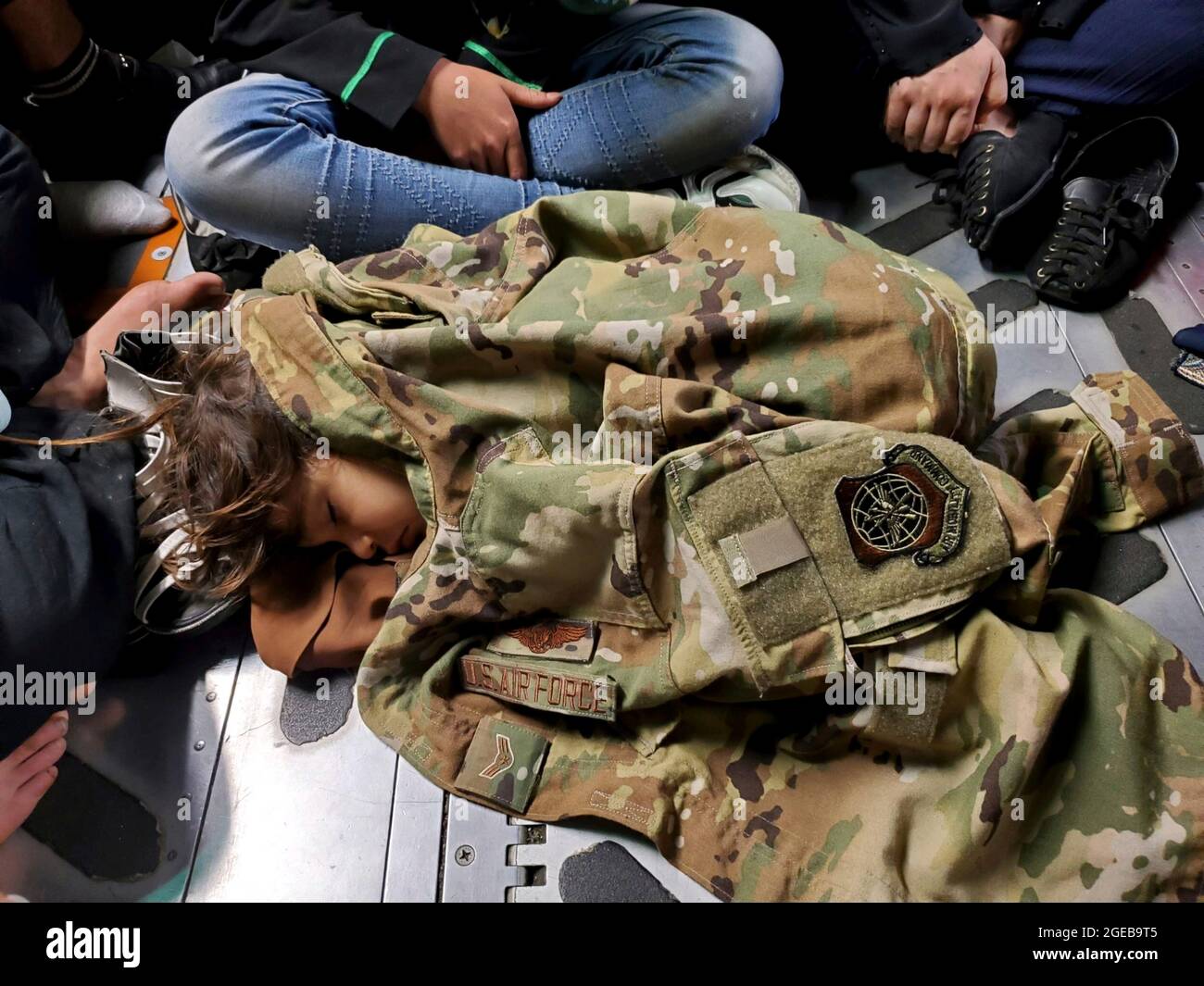 Kabul, Afghanistan. 18th Aug, 2021. An Afghan child sleeps on the cargo floor of a U.S. Air Force C-17 Globemaster III cargo aircraft, kept warm by a borrowed uniform jacket, during an evacuation flight from Hamid Karzai International Airport August 18, 2021 in Kabul, Afghanistan, Aug. 18, 2021. Credit: Planetpix/Alamy Live News Stock Photo