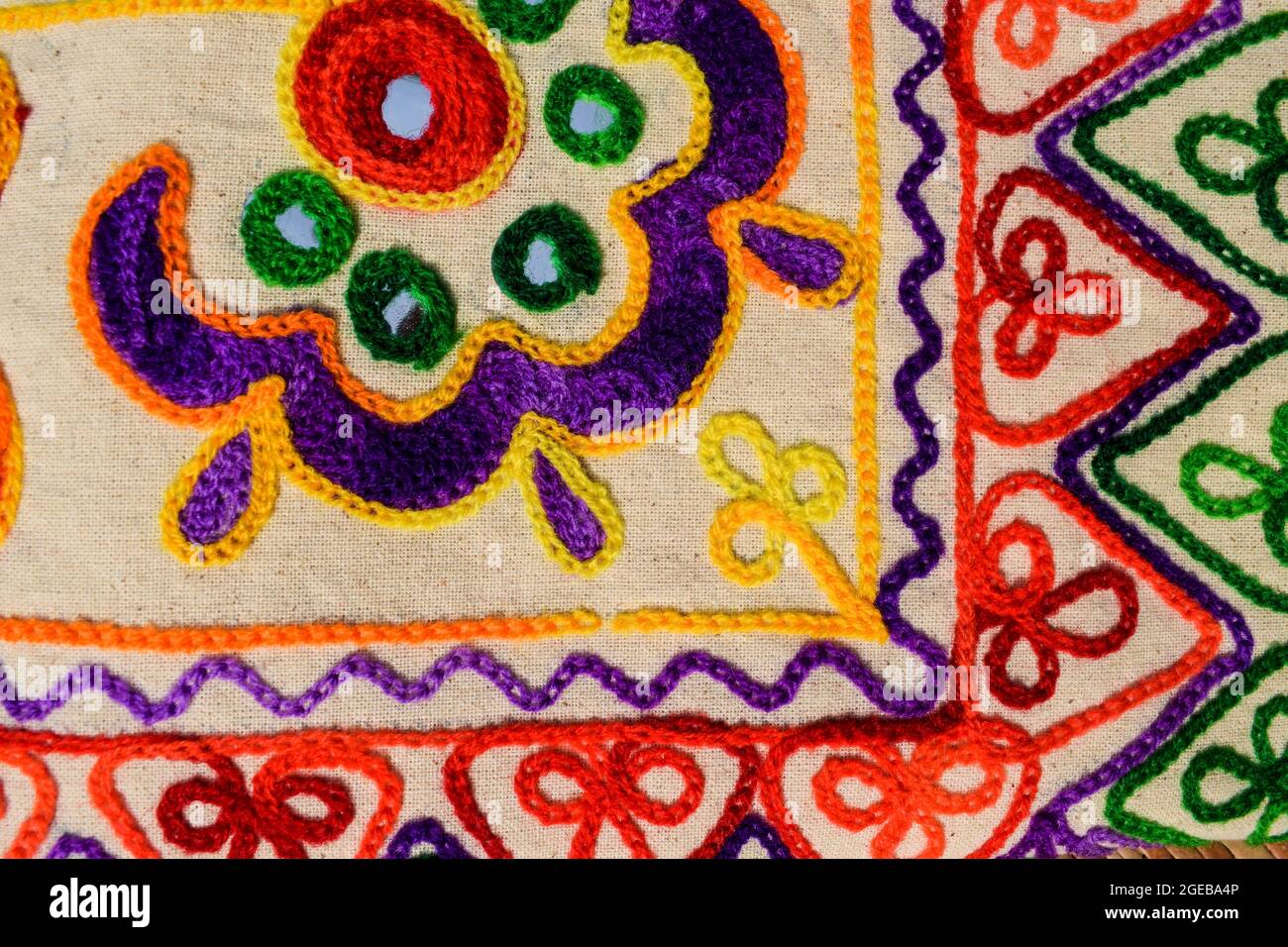 Beautiful embroidery multicoloured hand crafted thread work with mirrorwork from Kutch district bhuj called Kutchi embroidery. Embroidery work backdro Stock Photo
