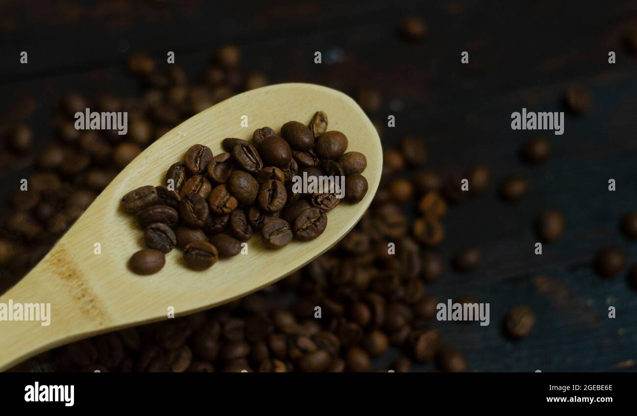 Wooden spoon with coffee beans on rustic coffee background Stock Photo ...