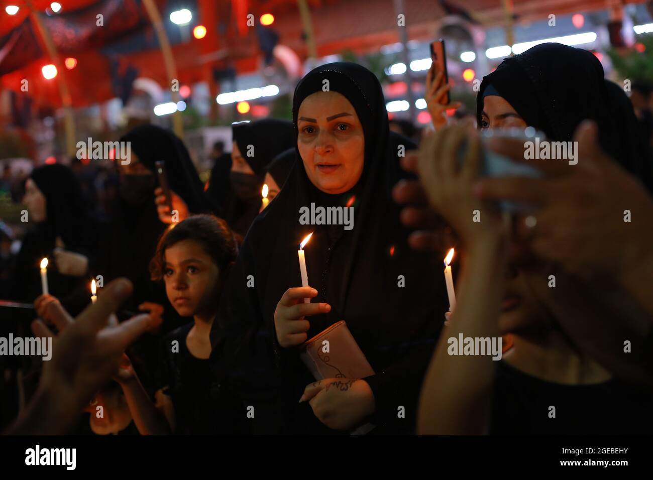Karbala, Iraq. 18th Aug, 2021. Iraqi Shiite Muslims take part in the mourning procession on the eve of Ashura Day, held on the 9th day of the month of Muharram, the first month of the Islamic calendar, at the Imam Abbas shrine in Iraq's holy city of Karbala. Muharram is considered a month of mourning and remembrance for Shiite Muslims around the world, in which they commemorate the martyrdom of the grandson of the Islamic prophet Mohammad, Husayn ibn Ali, who was killed in the 7th century Battle of Karbala. Credit: Ameer Al Mohammedaw/dpa/Alamy Live News Stock Photo