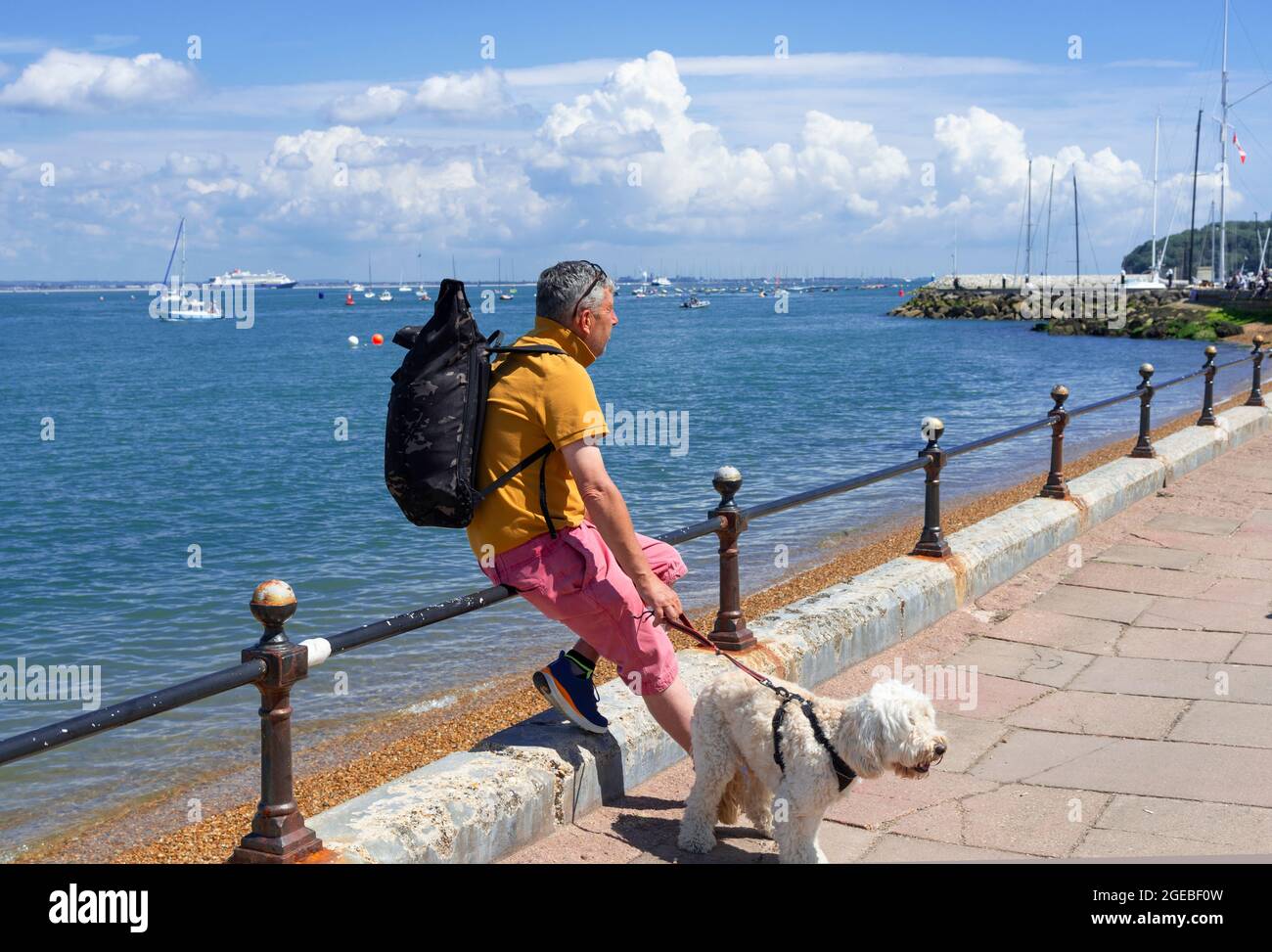 Man walking his dog on the esplanade at Cowes, Isle of Wight, England