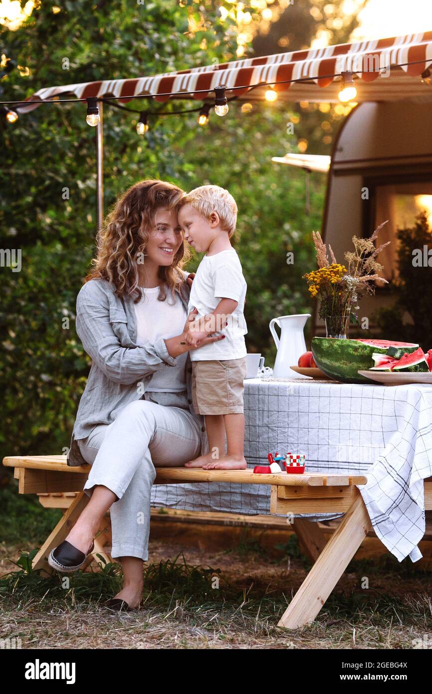 Young mom embrace small kid outdoor at camper van. Happy mother cuddling  little son during road trip Stock Photo - Alamy