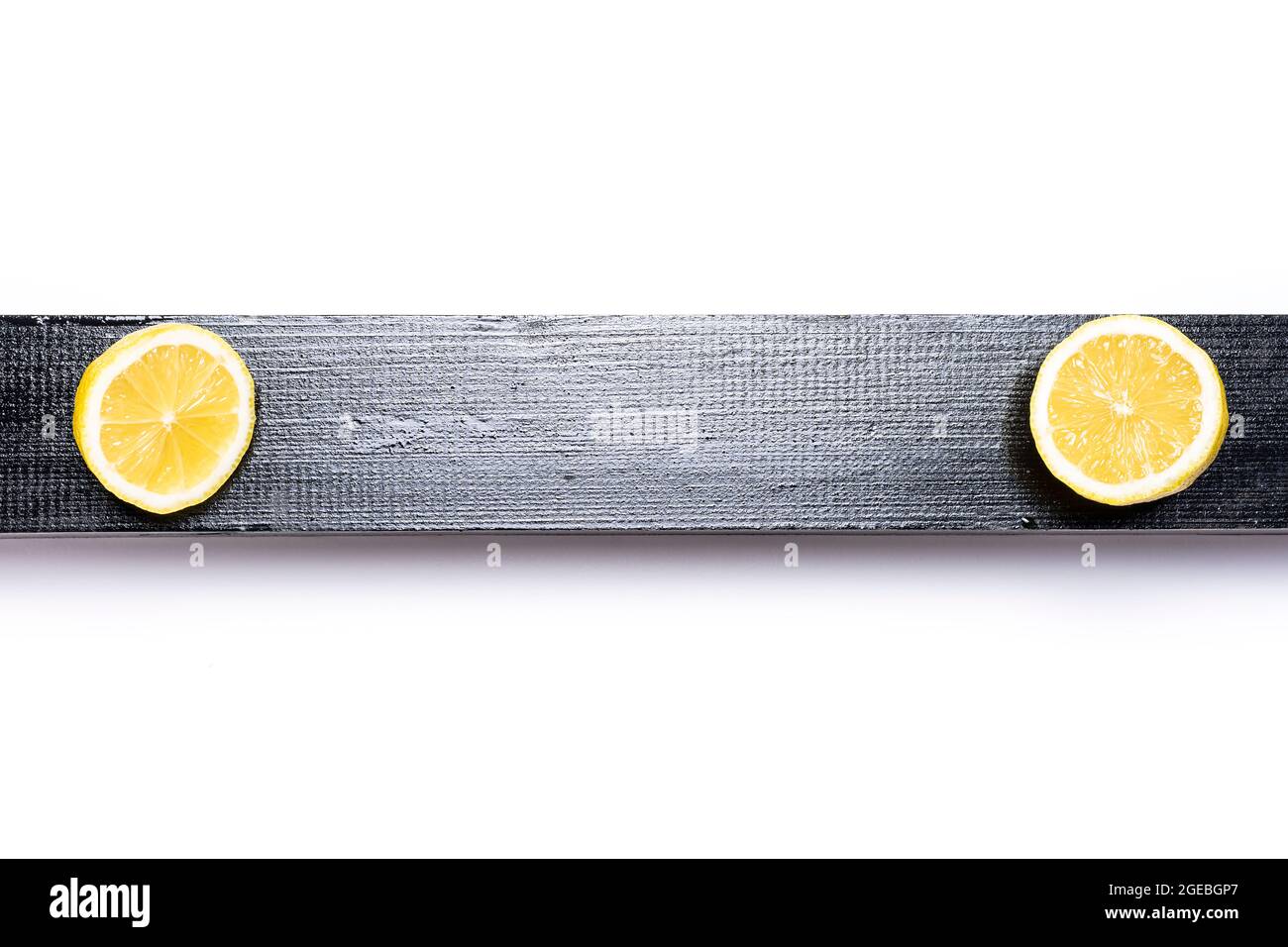 Horizontal Lemon Photo of a yellow lemon in two halves on a black wooden slat and a ...