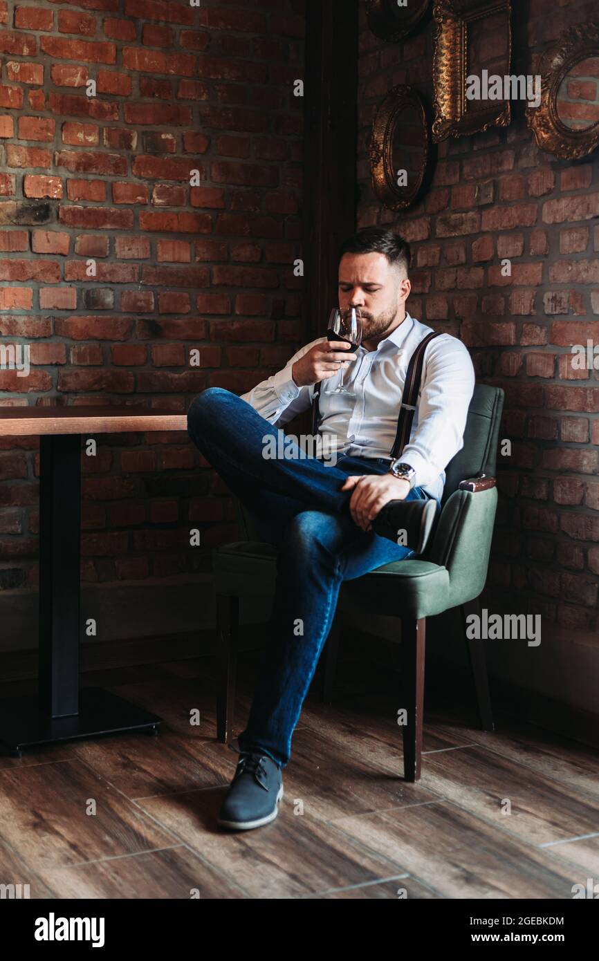 Handsome young man enjoying a glass of red wine Stock Photo