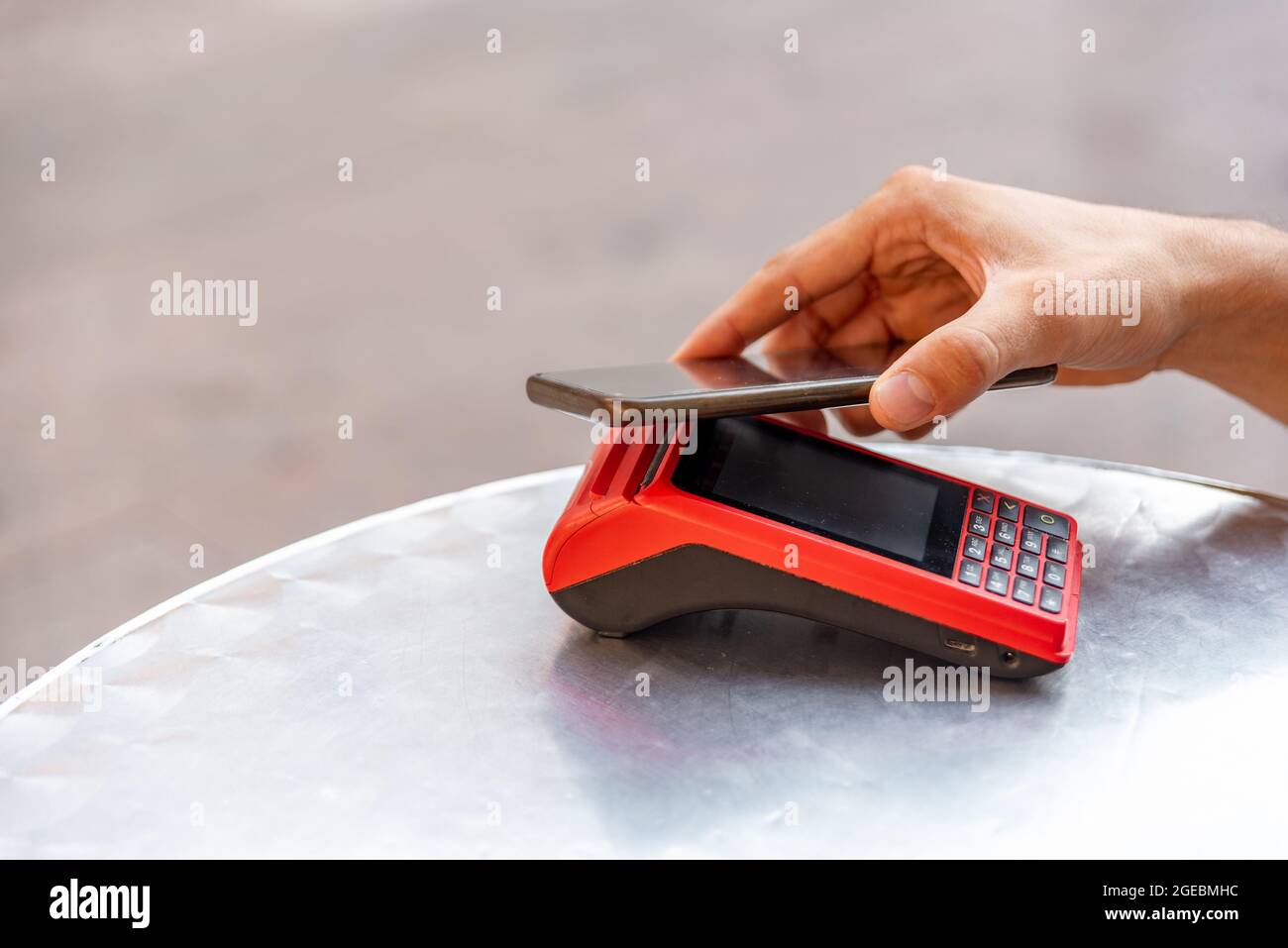 Unrecognizable man paying with mobile phone in the machine Stock Photo