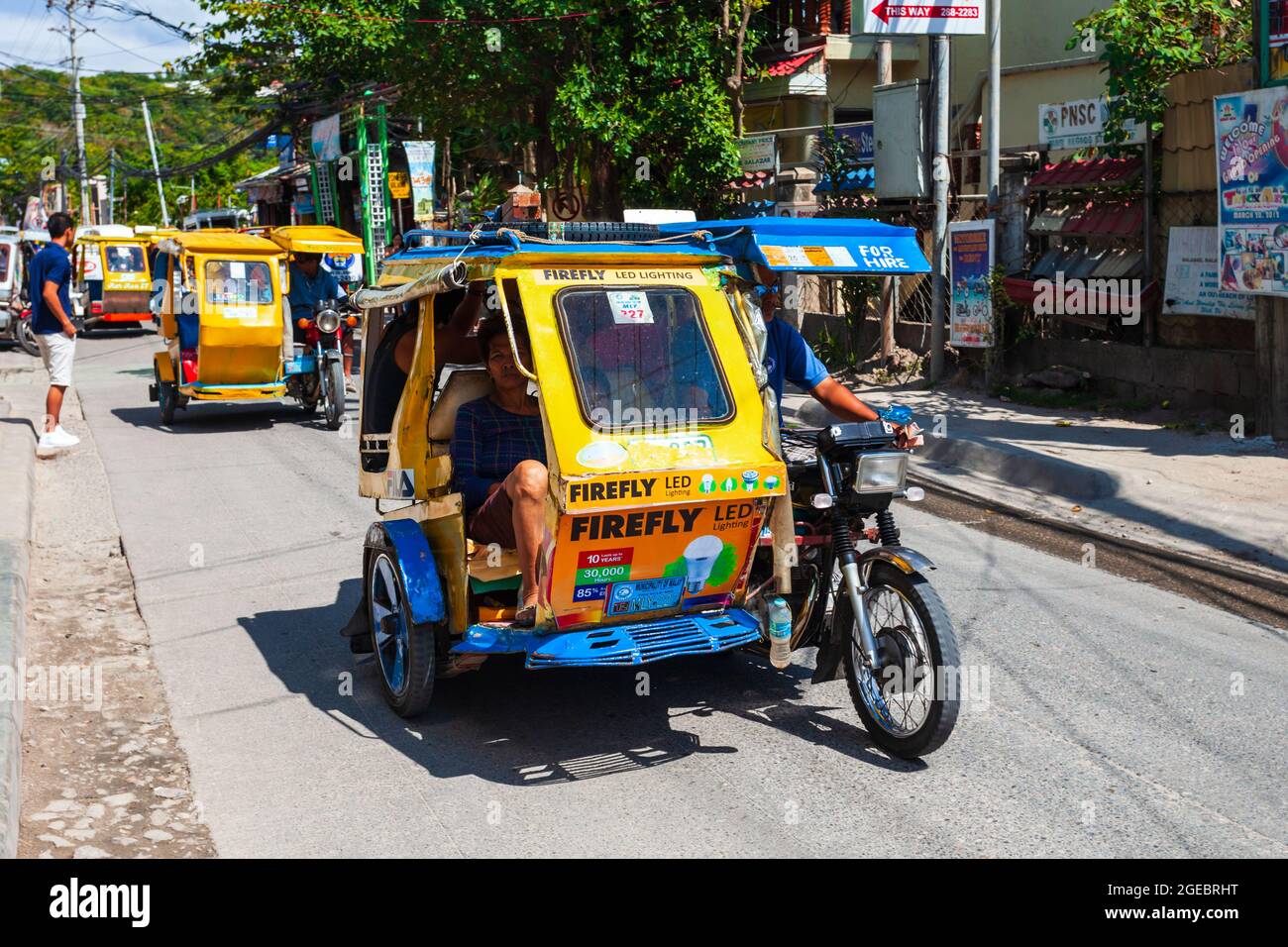 BORACAY, PHILIPPINES - MARCH 04, 2013: Tricycle at the main street in Boracay island. Tricycle is a very popular public taxi transport in Philippines. Stock Photo