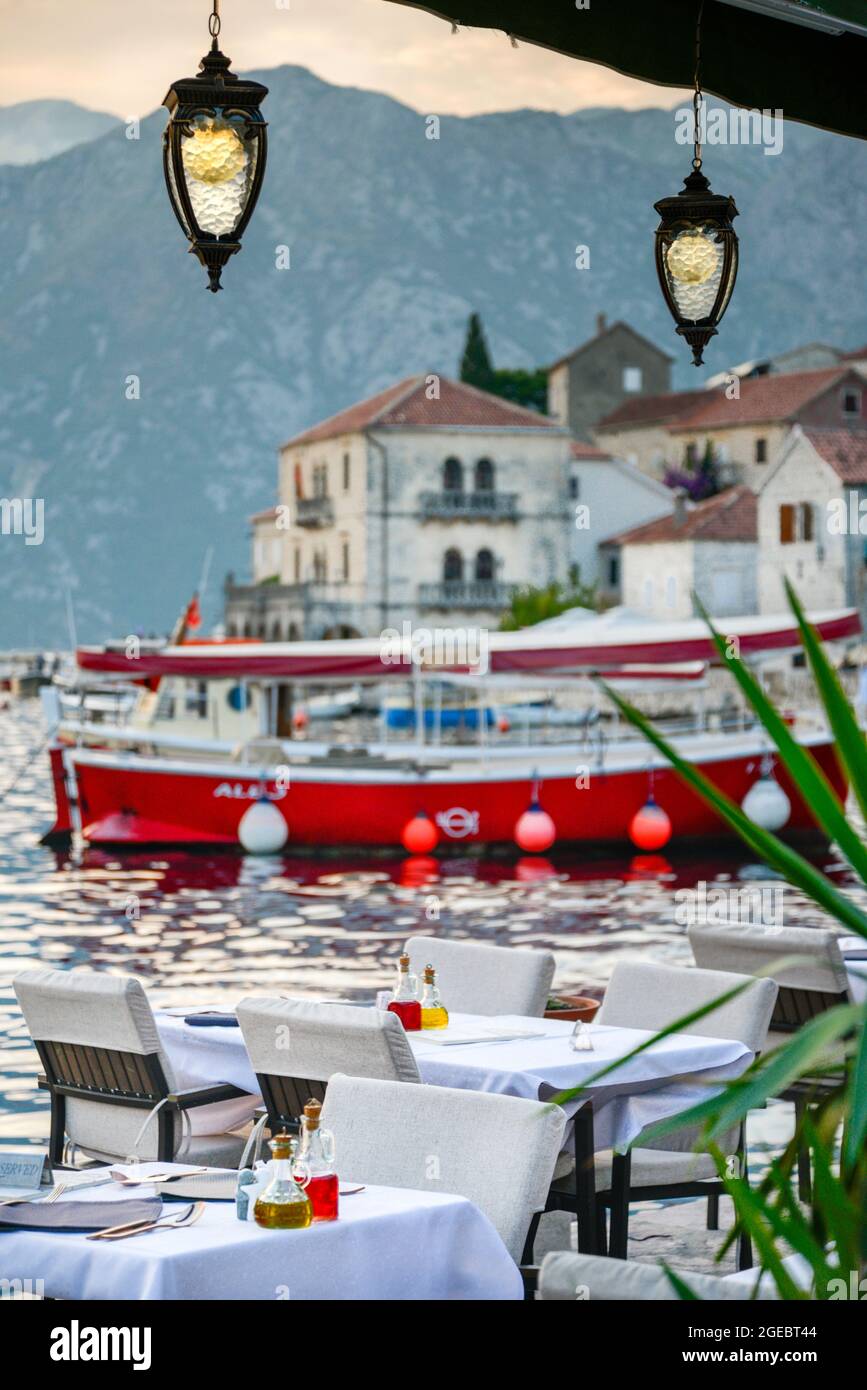 A beautiful romantic tourist destination by the edge of Kotor Bay in late summer with cutlery,condiments and napkins freshly arranged for the evening Stock Photo