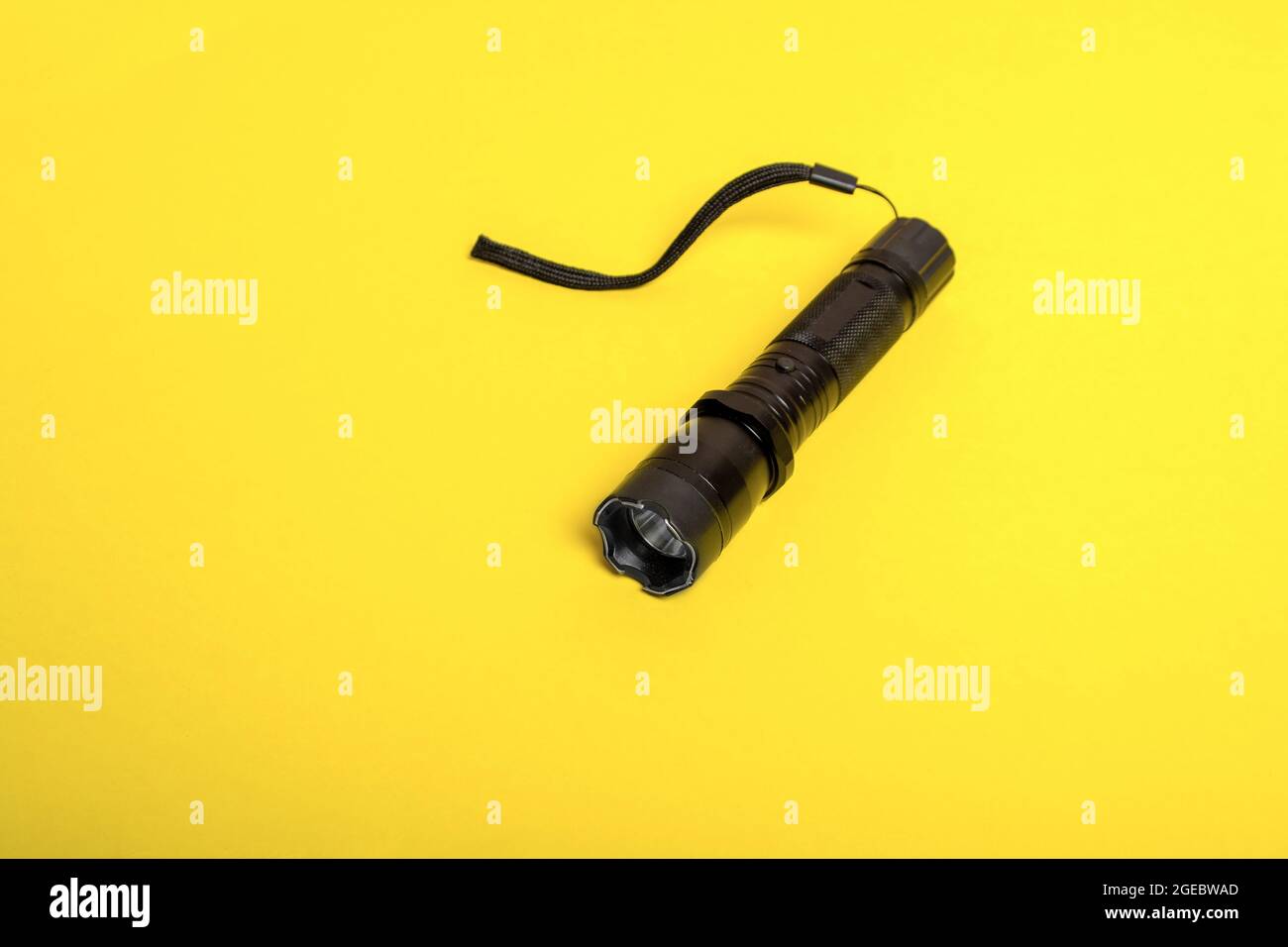 black flashlight shocker on a yellow background. Stock Photo