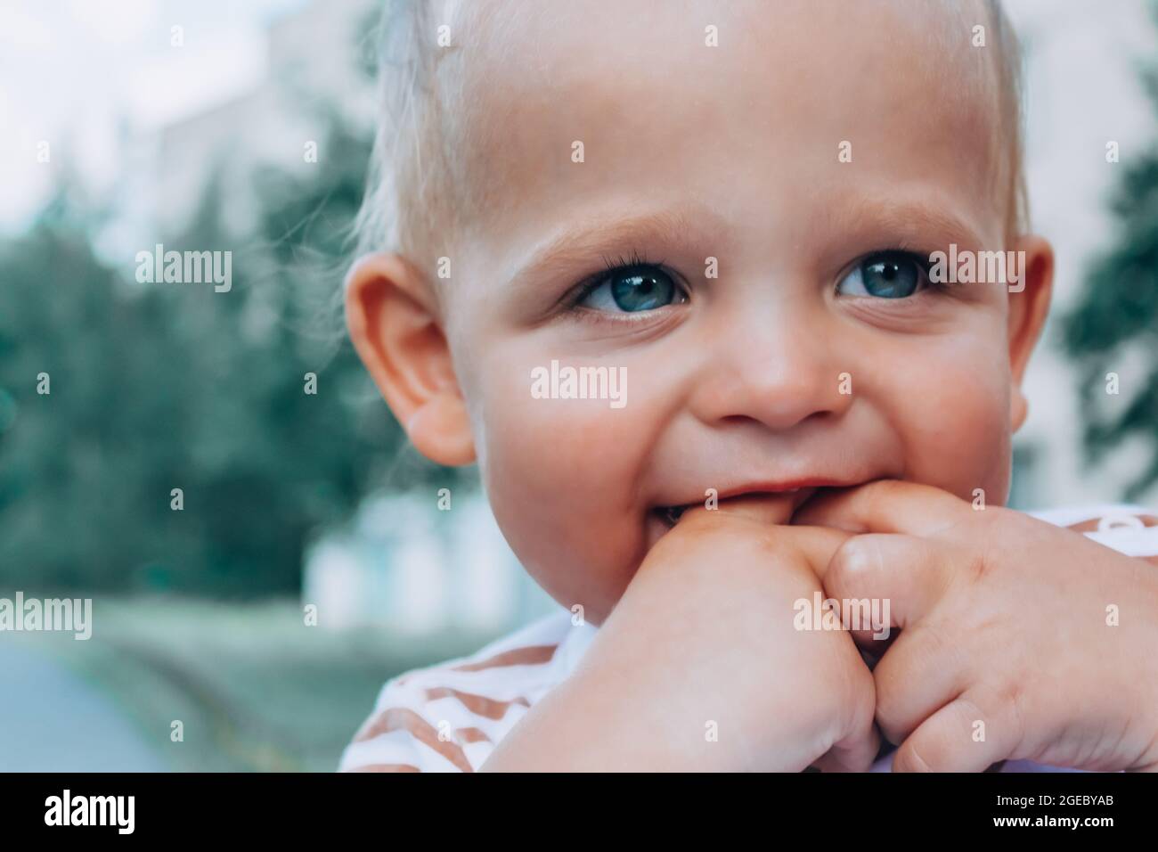 Little baby boy holding fingers in mouth. Stock Photo