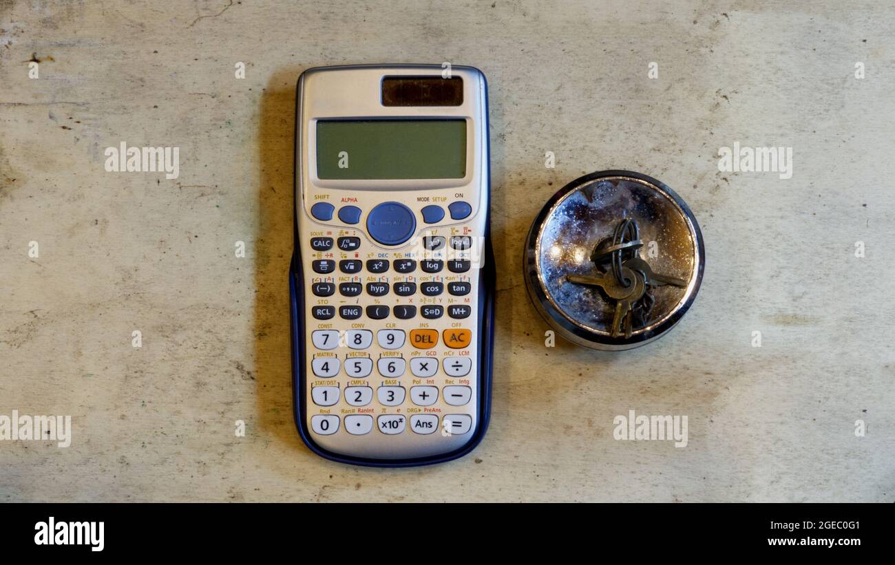 A Calculator and Locking Gas Cap on a Wooden Background Stock Photo
