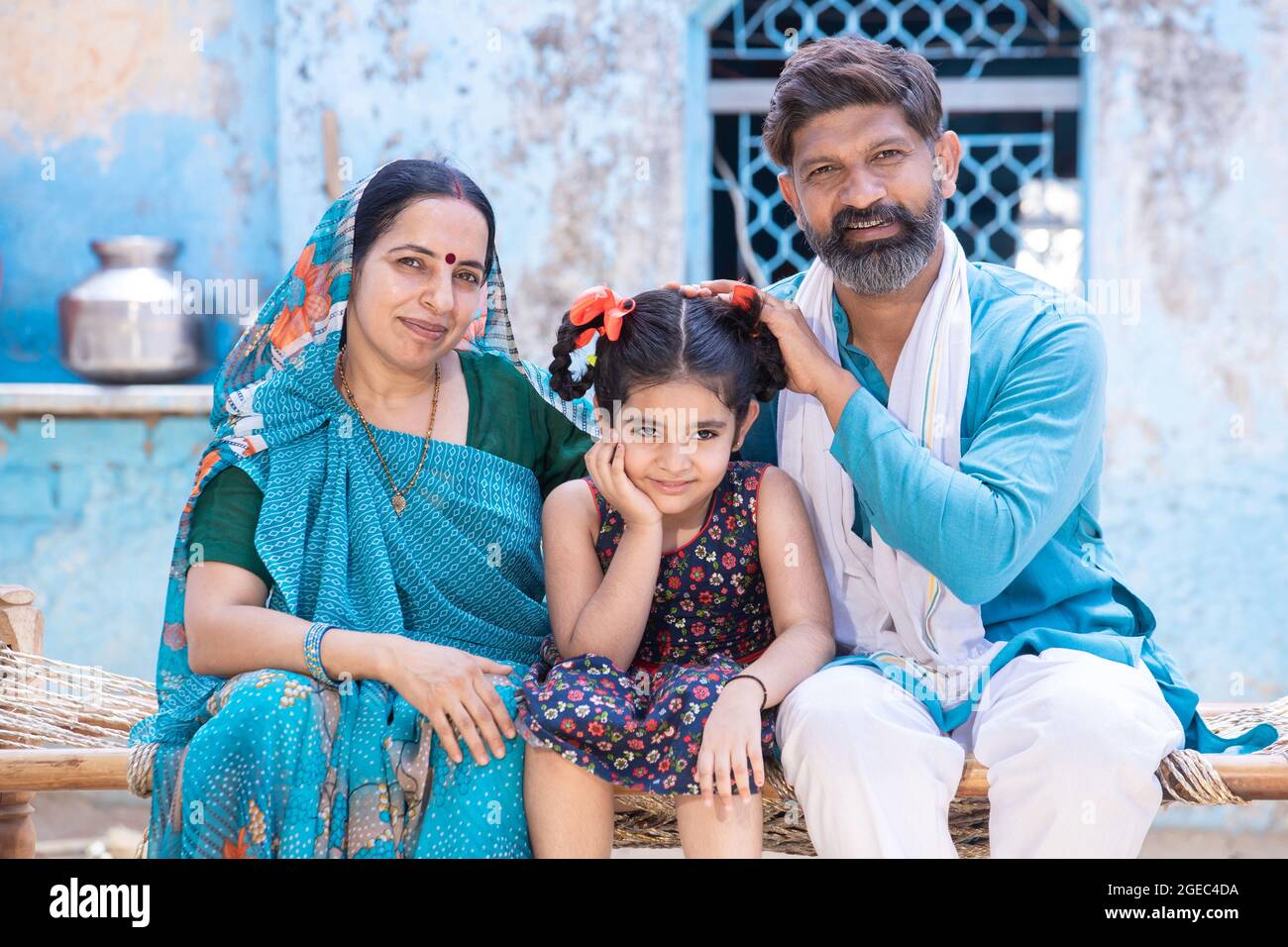 Portrait of happy rural indian parents support girl child, family ...