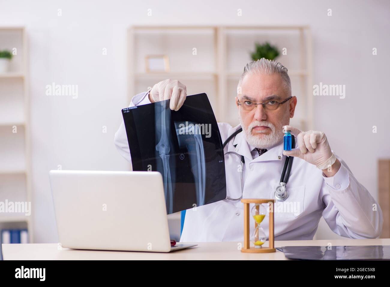 Old doctor in time management concept Stock Photo