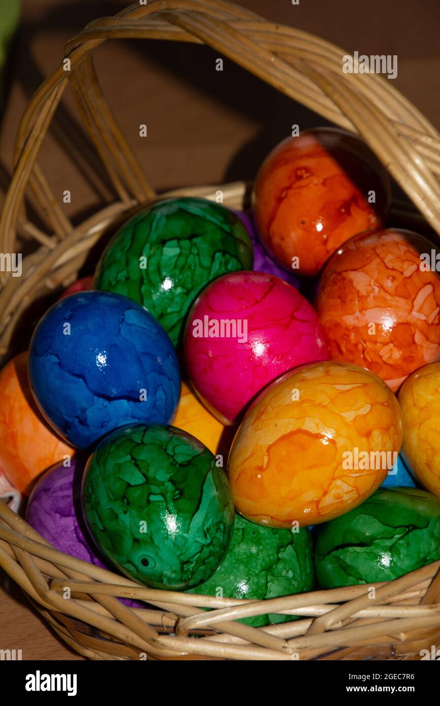 simple easter concept with bright colored easter eggs in wicker basket Stock Photo
